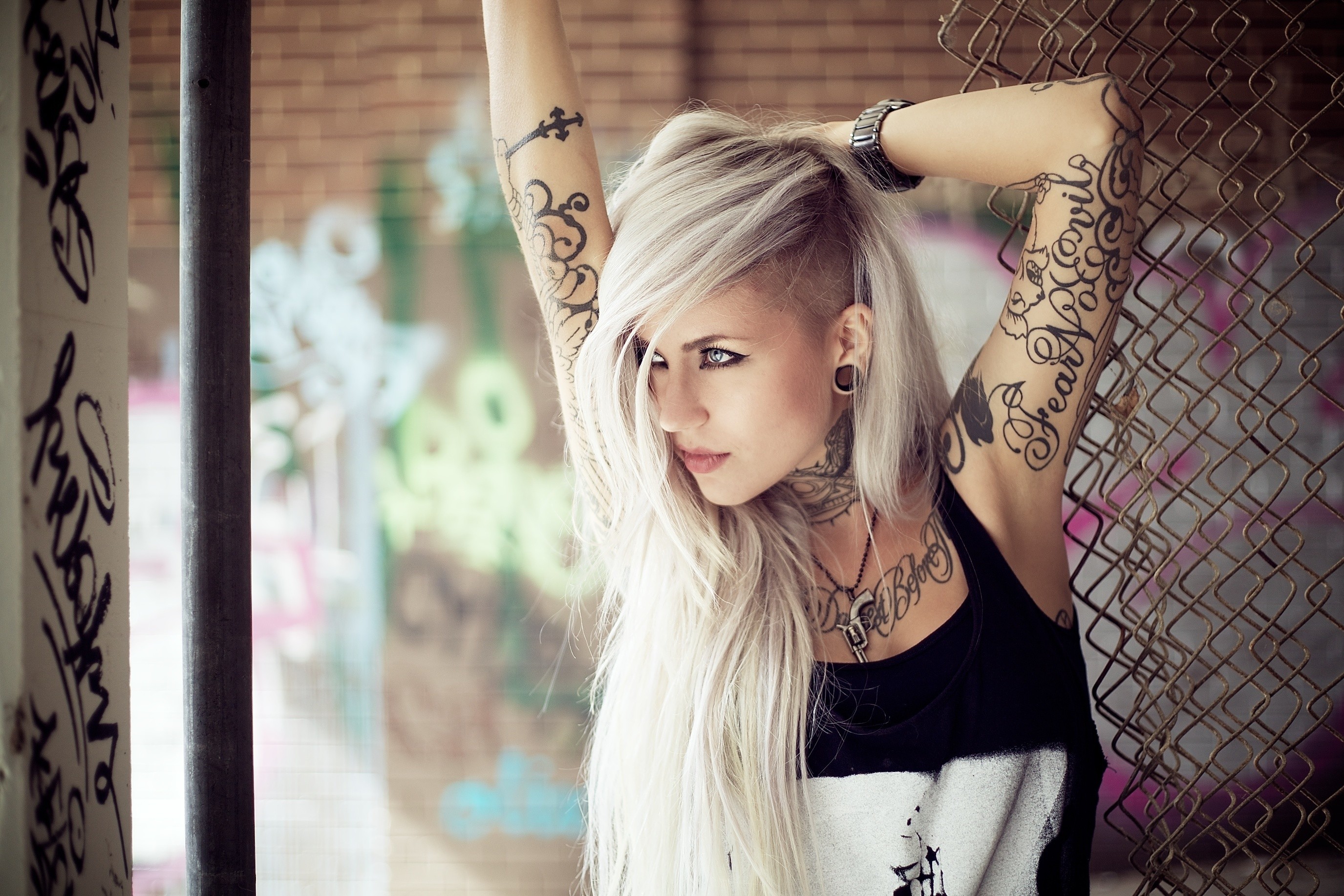 Tattooed woman with blonde hair in urban setting HD Wallpaper