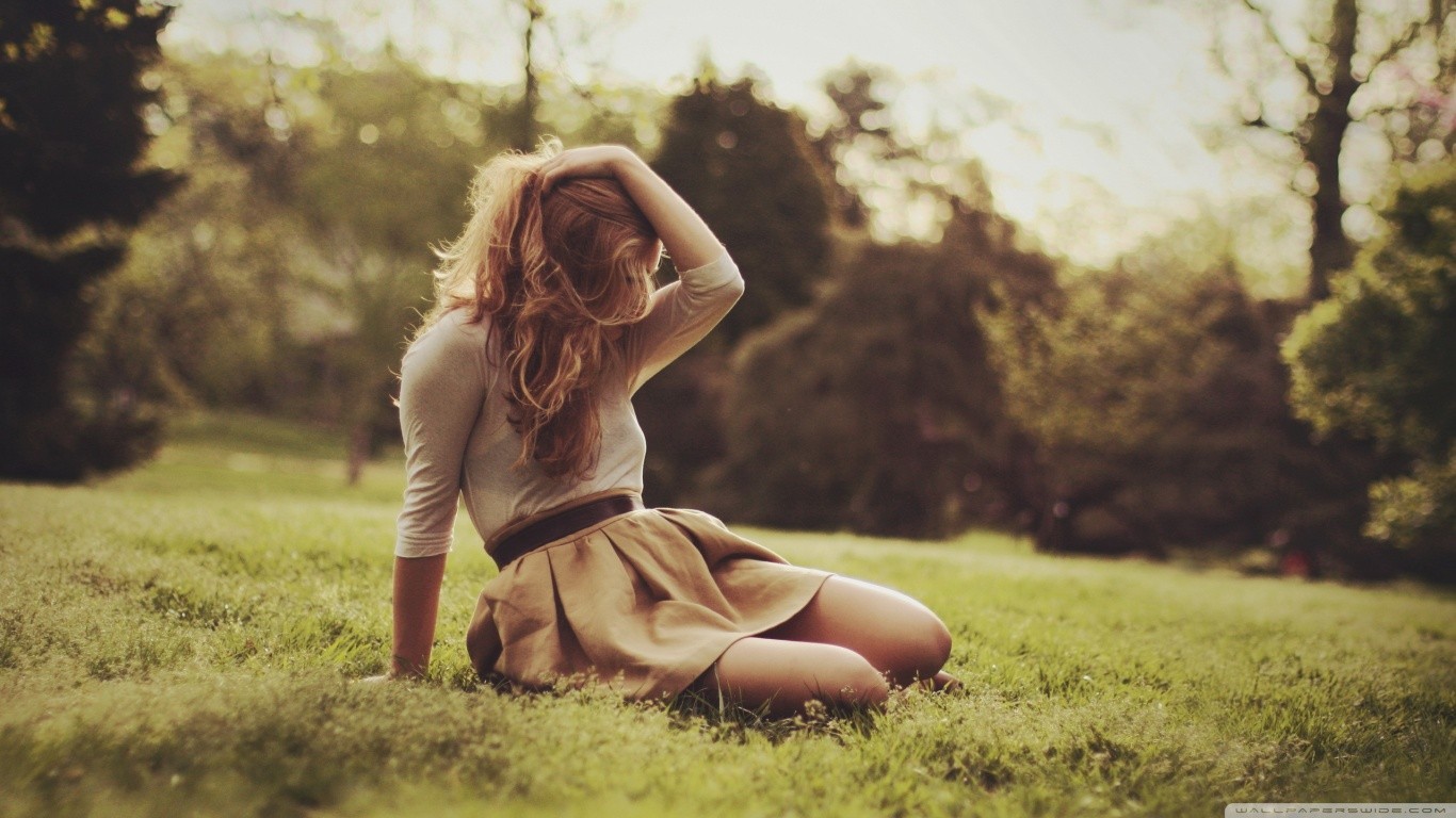 Woman in skirt sitting on grass outdoors HD Wallpaper