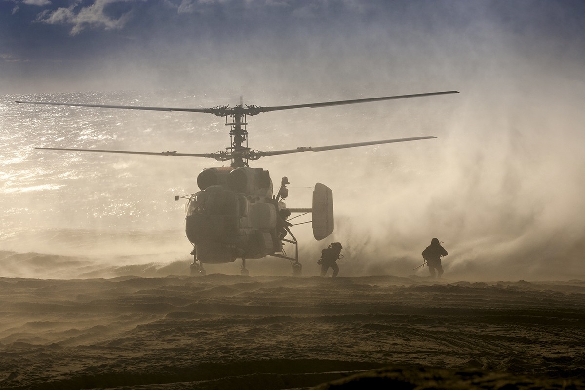 Military helicopter landing on a beach with soldiers HD Wallpaper