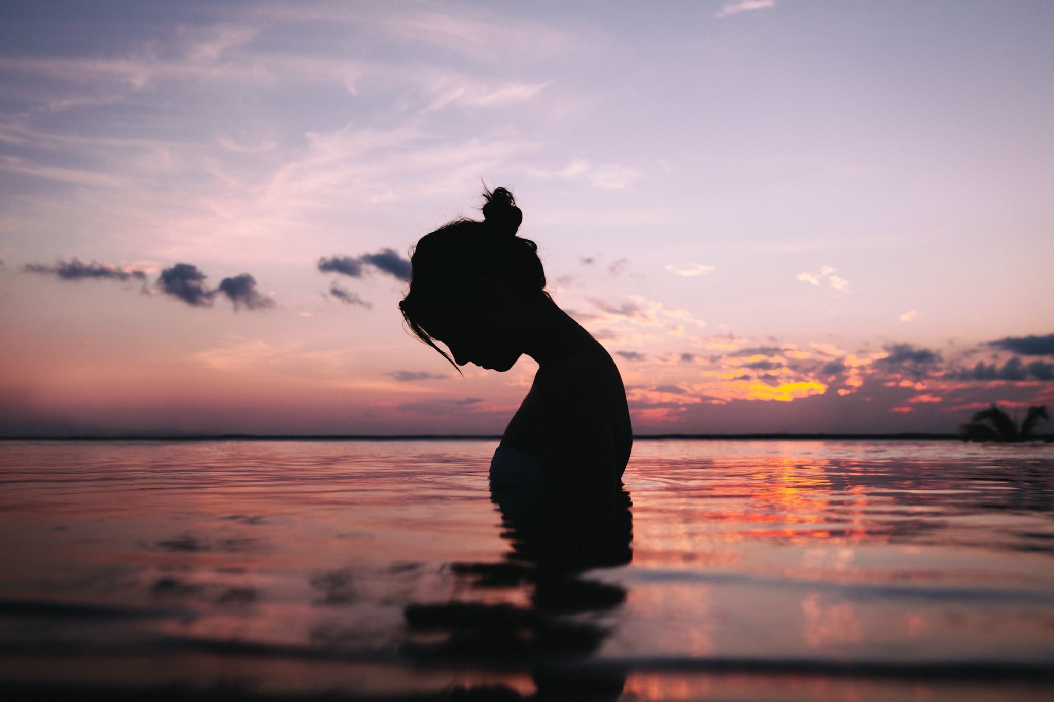 Silhouette of a woman in the sea at sunset HD Wallpaper