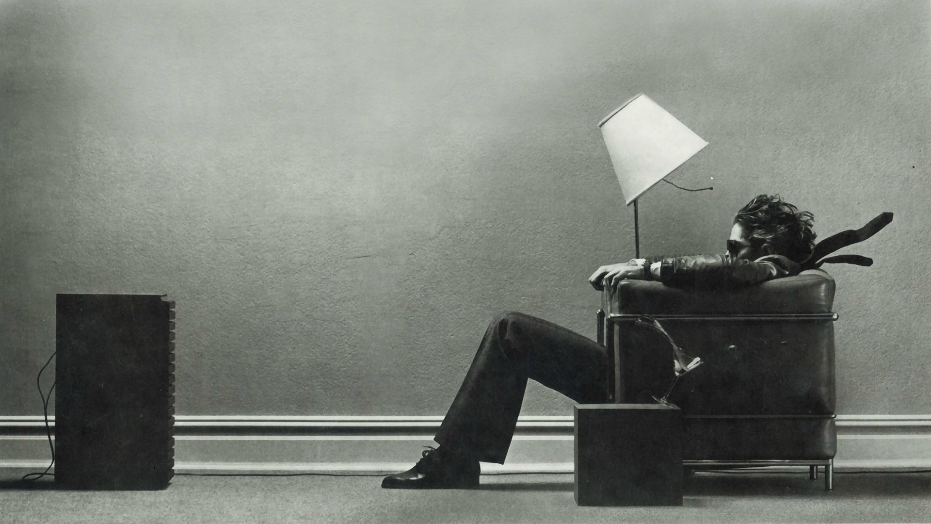 Man in armchair with lamp and speaker HD Wallpaper