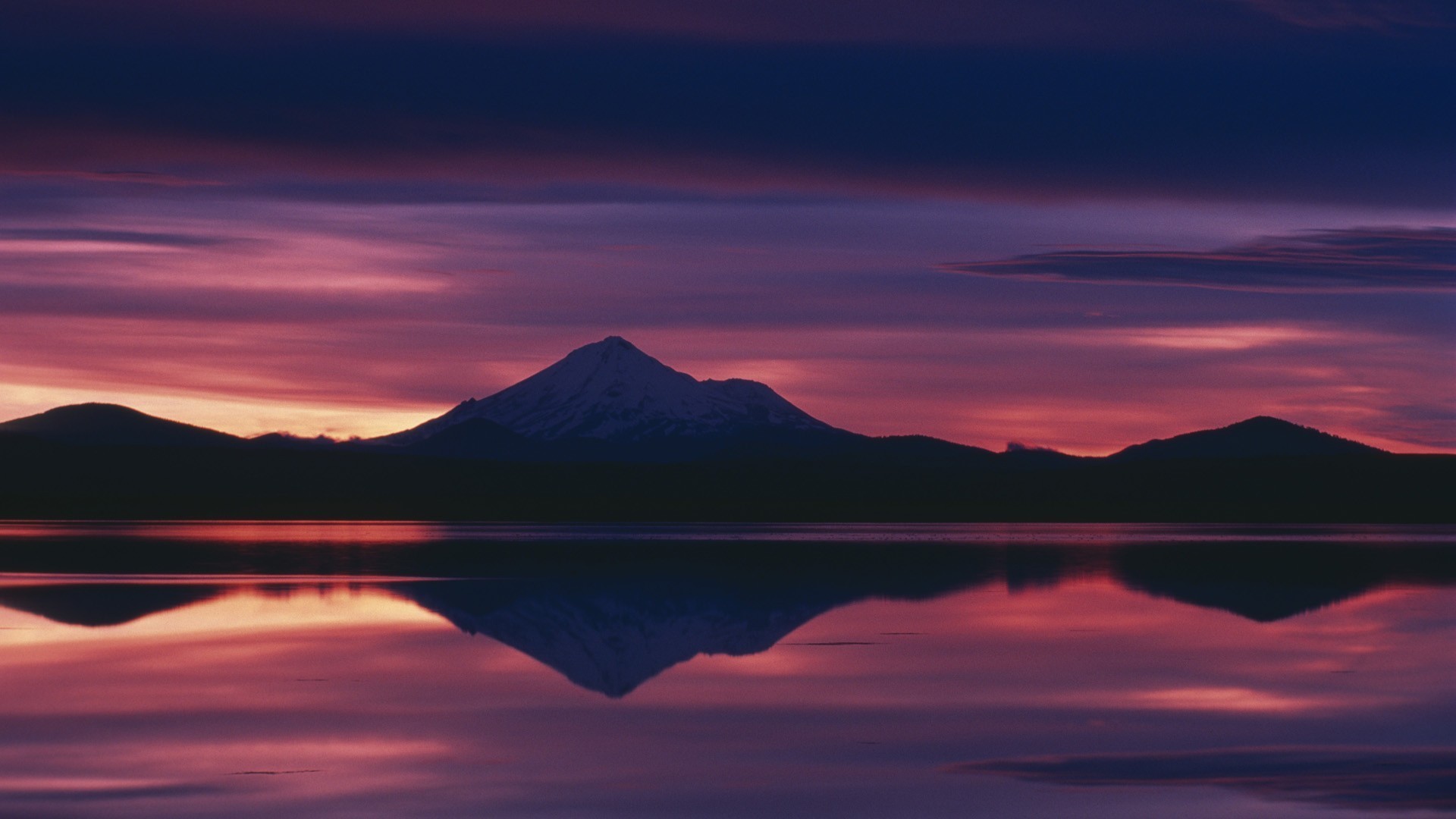 Mountain reflection at sunset over a calm lake HD Wallpaper