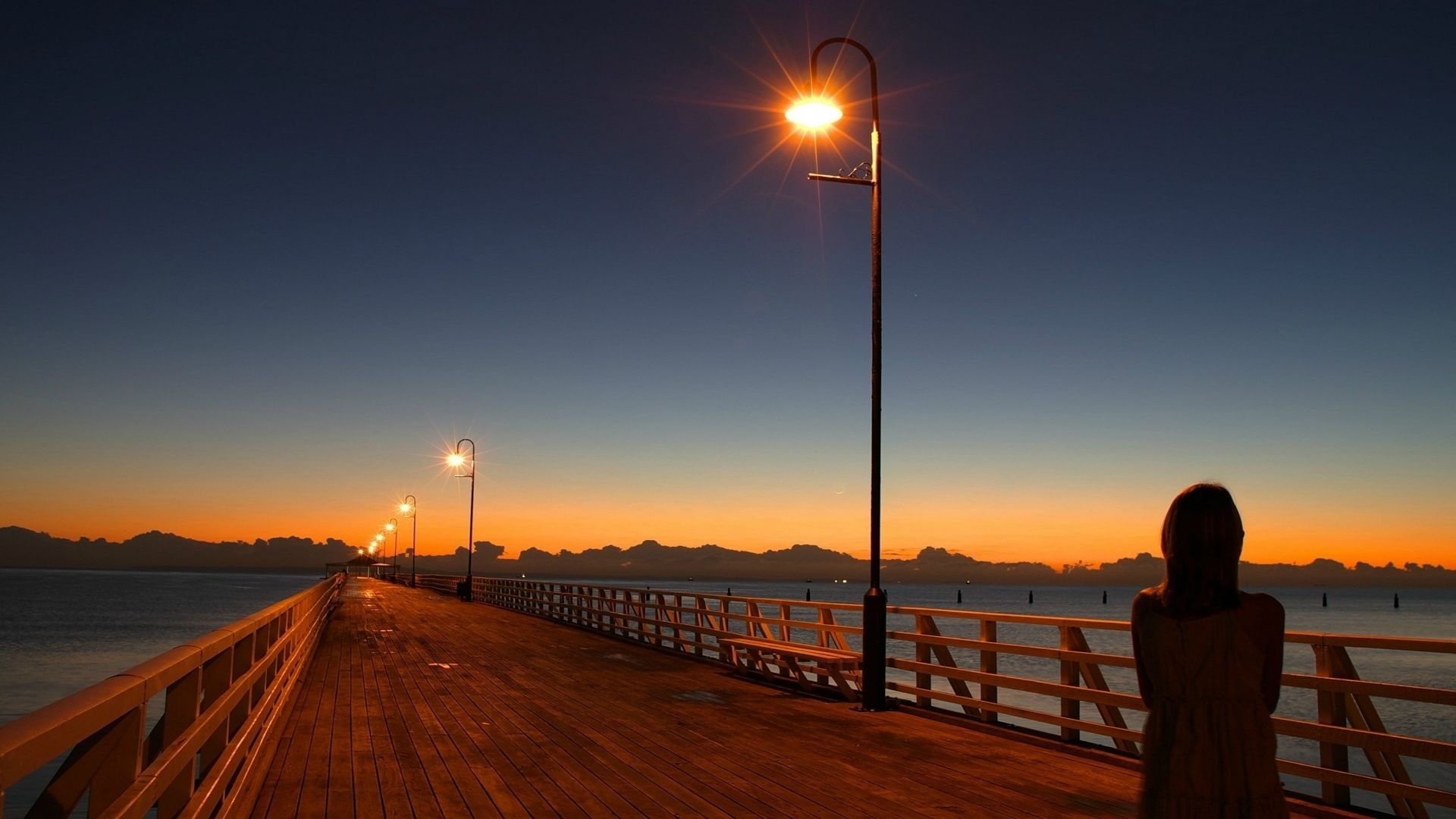 Person on a pier at sunset HD Wallpaper