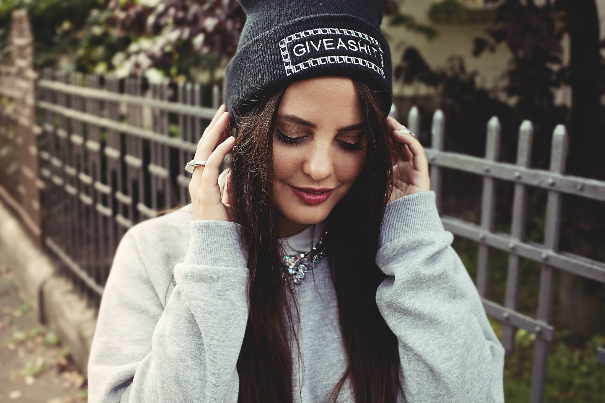 Woman wearing a beanie and sweatshirt outdoors HD Wallpaper