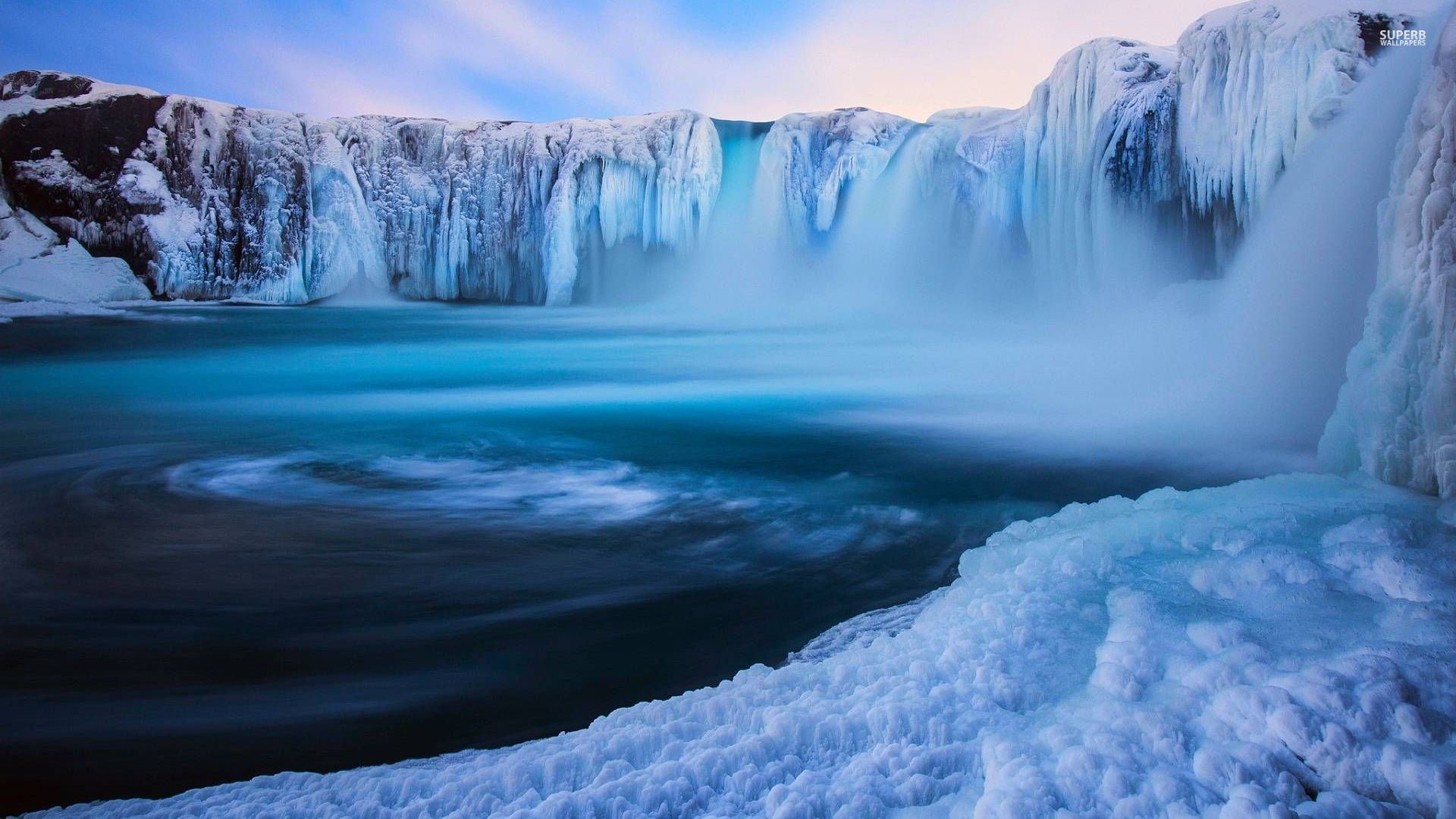 Frozen waterfall with icy cliffs and blue water HD Wallpaper