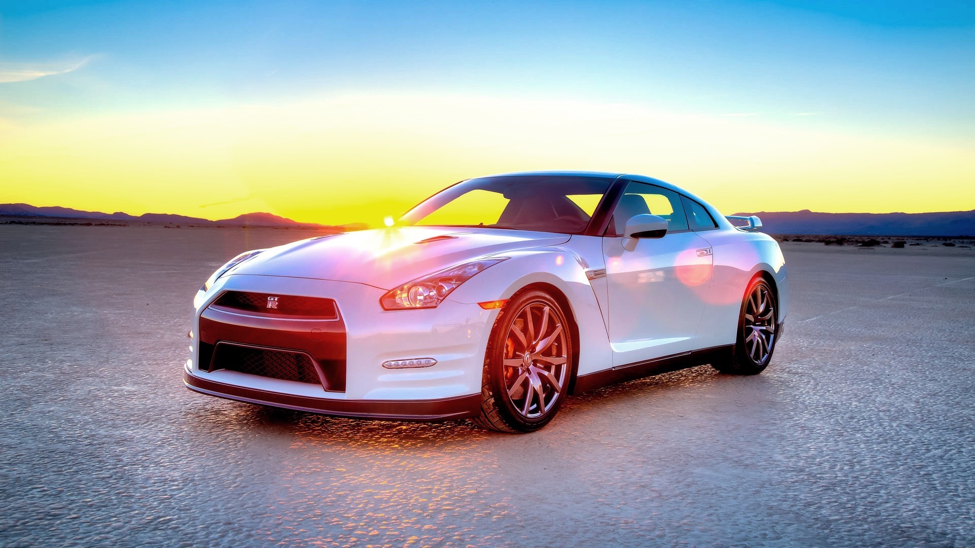 White Nissan GT-R in a desert landscape at sunset HD Wallpaper