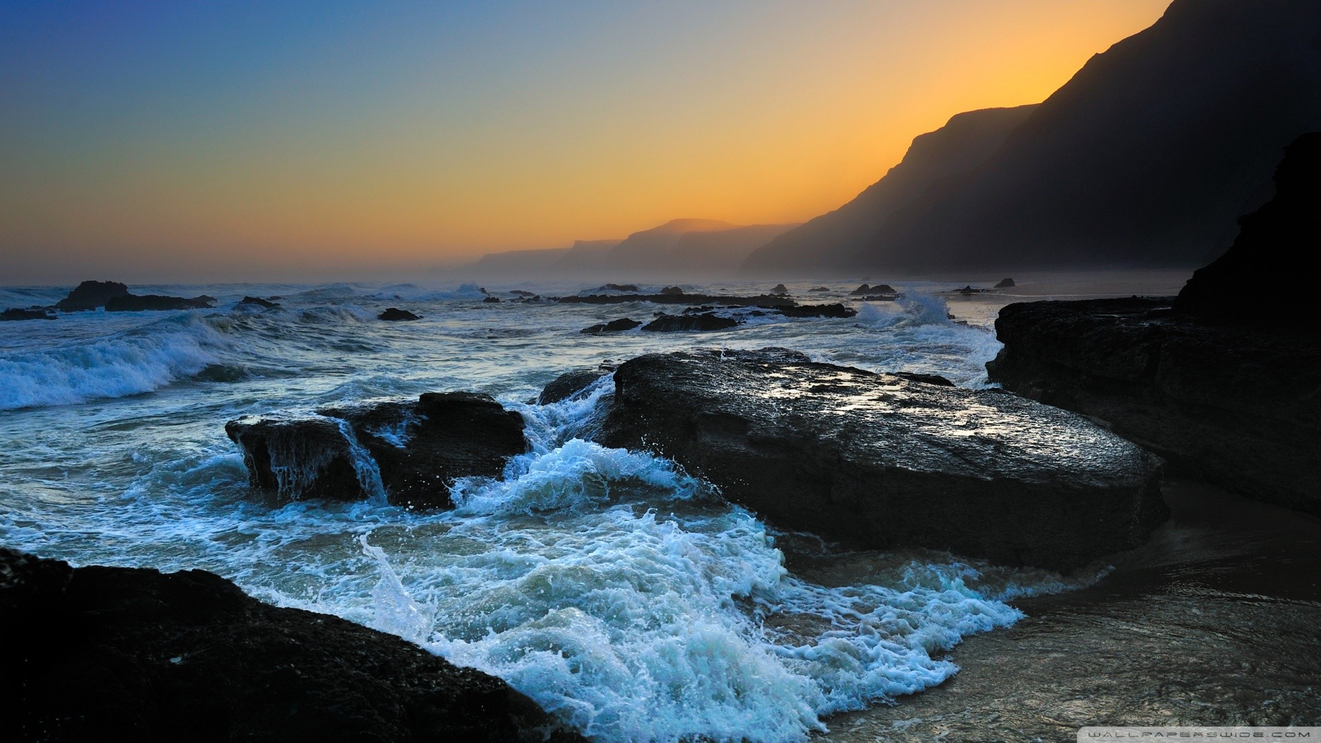 Waves crashing on rocks at sunset HD Wallpaper