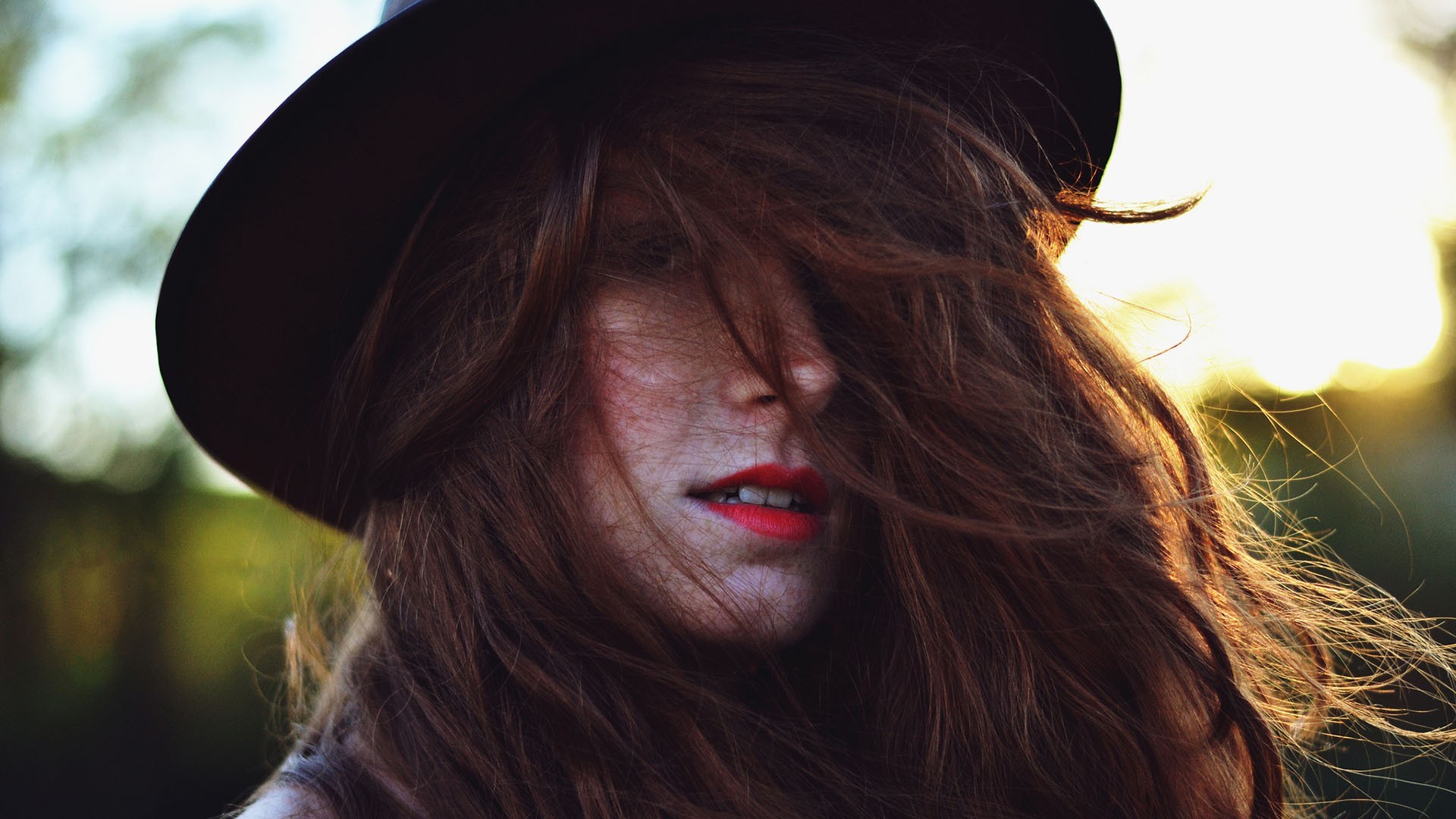 Woman with brown hair and hat in sunlight HD Wallpaper