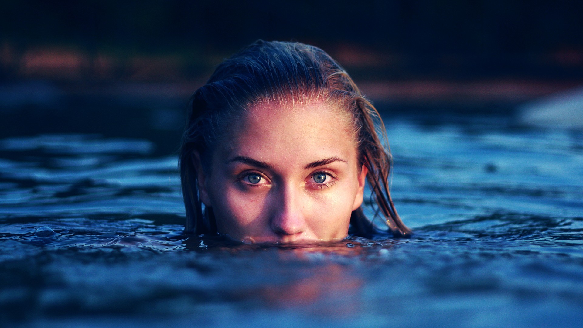 Woman with blue eyes emerging from dark water HD Wallpaper
