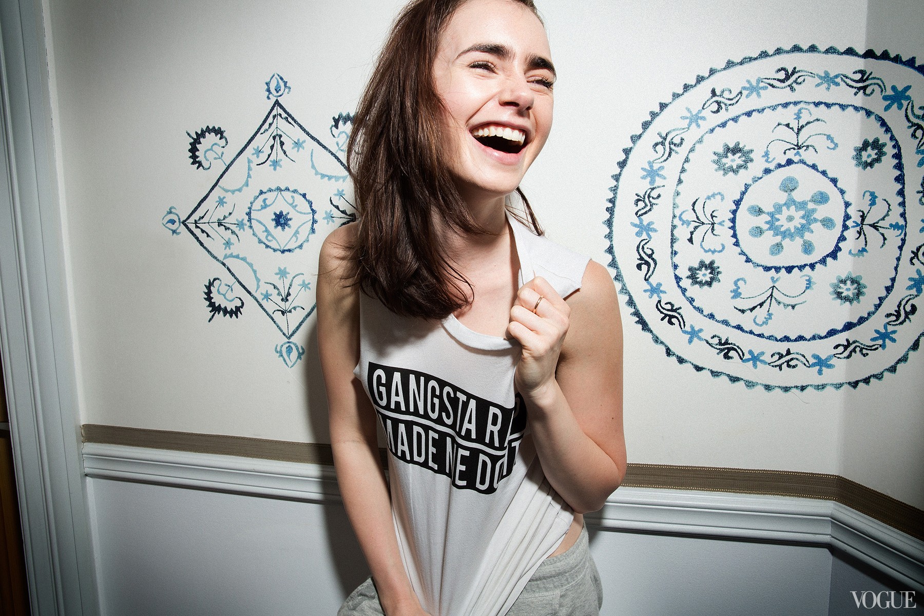 Lily Collins laughing in front of patterned wall HD Wallpaper