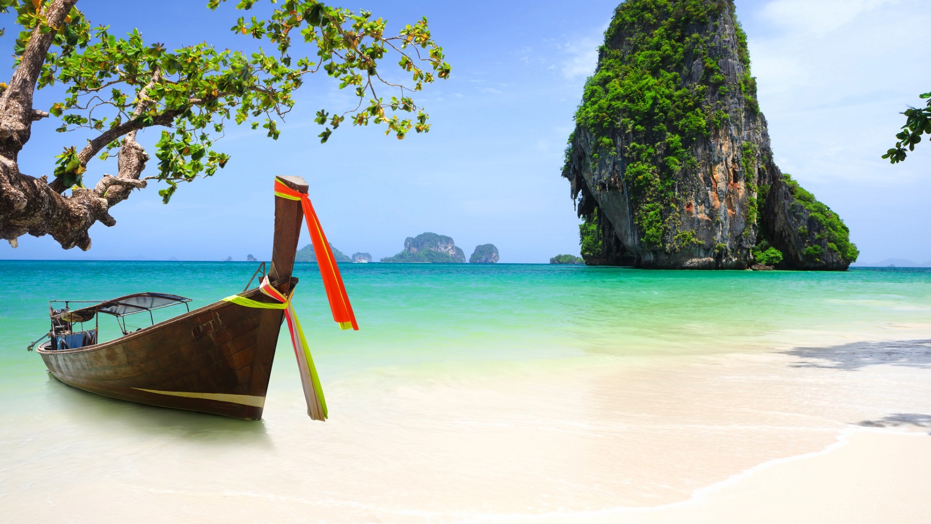 Longtail boat on a tropical beach with limestone karsts HD Wallpaper