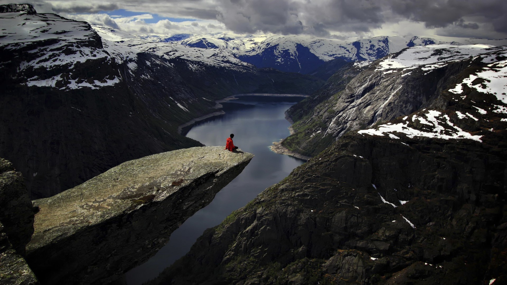 Person sitting on Trolltunga cliff overlooking Ringedalsvatnet lake HD Wallpaper