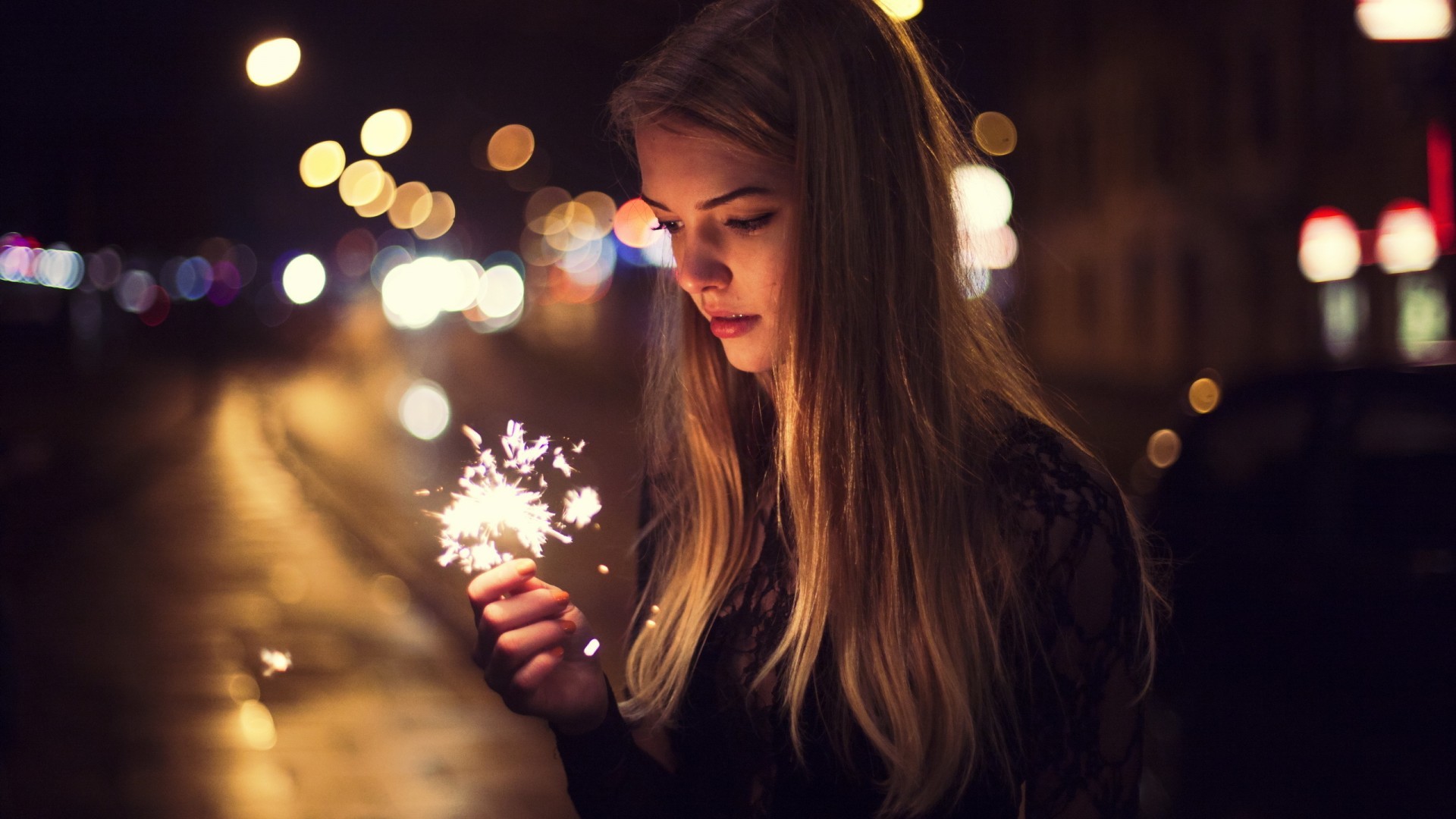 Woman holding a sparkler at night HD Wallpaper