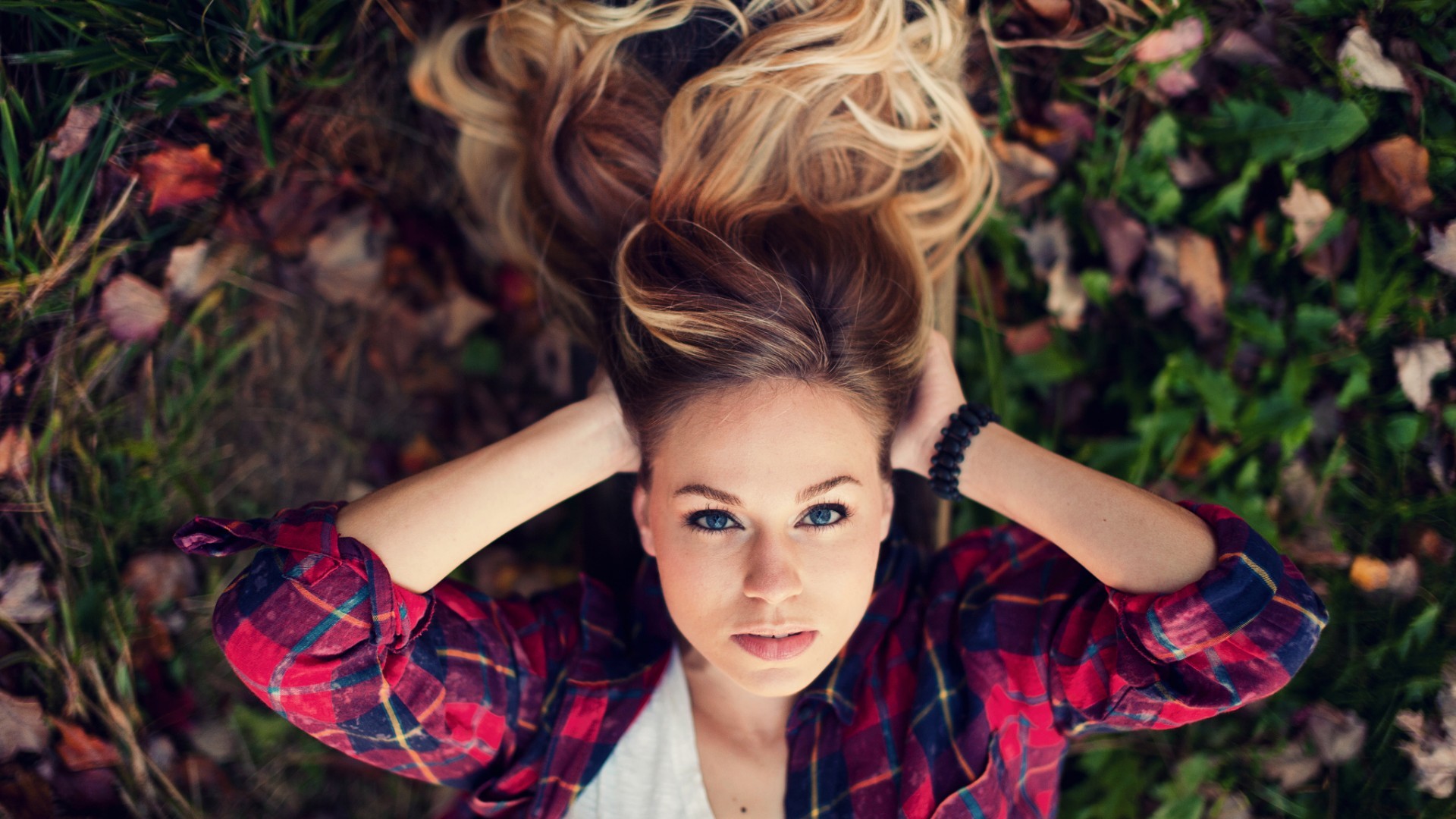 Woman lying on the ground with hands in hair HD Wallpaper
