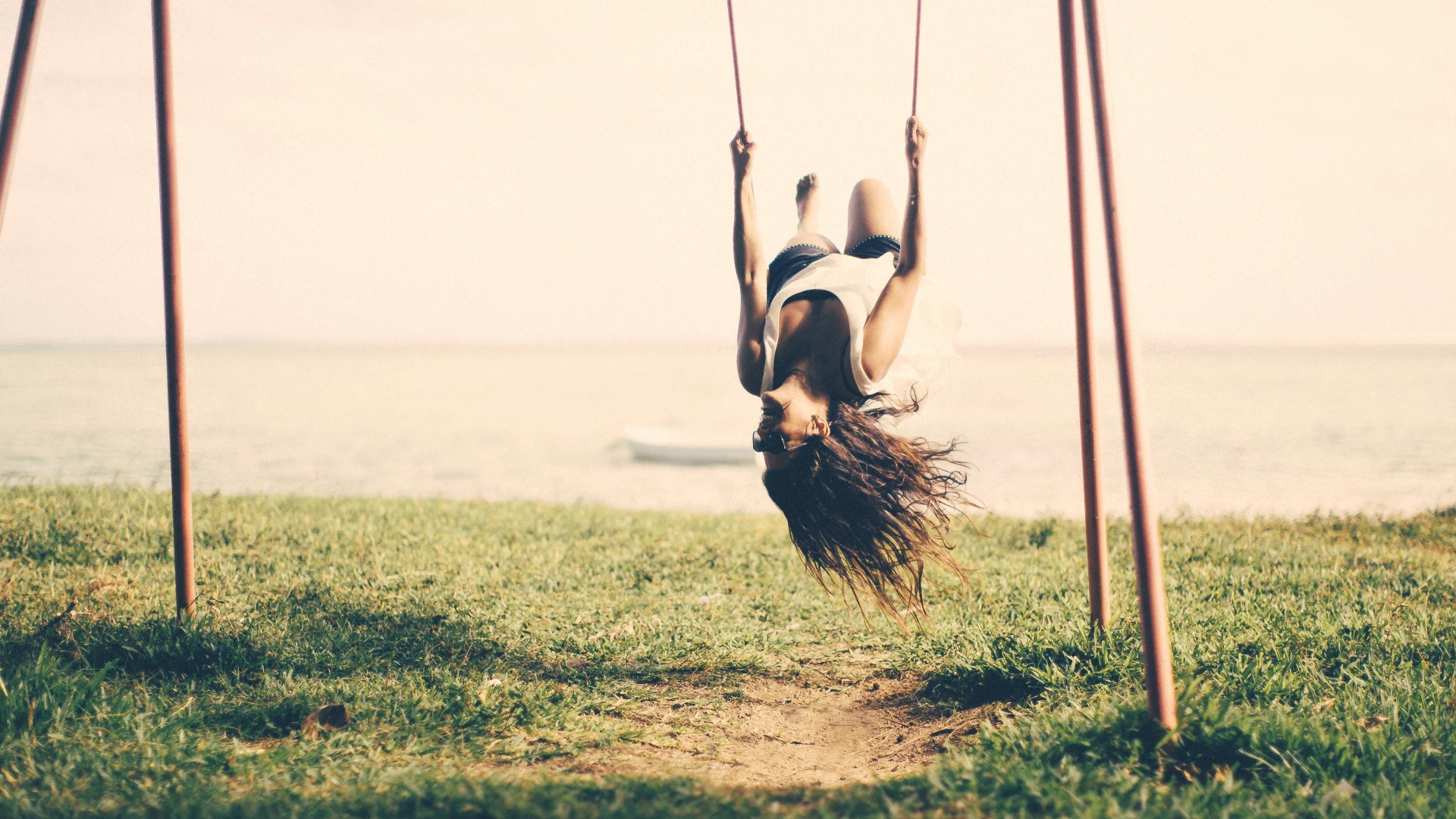 Woman swinging upside down outdoors HD Wallpaper