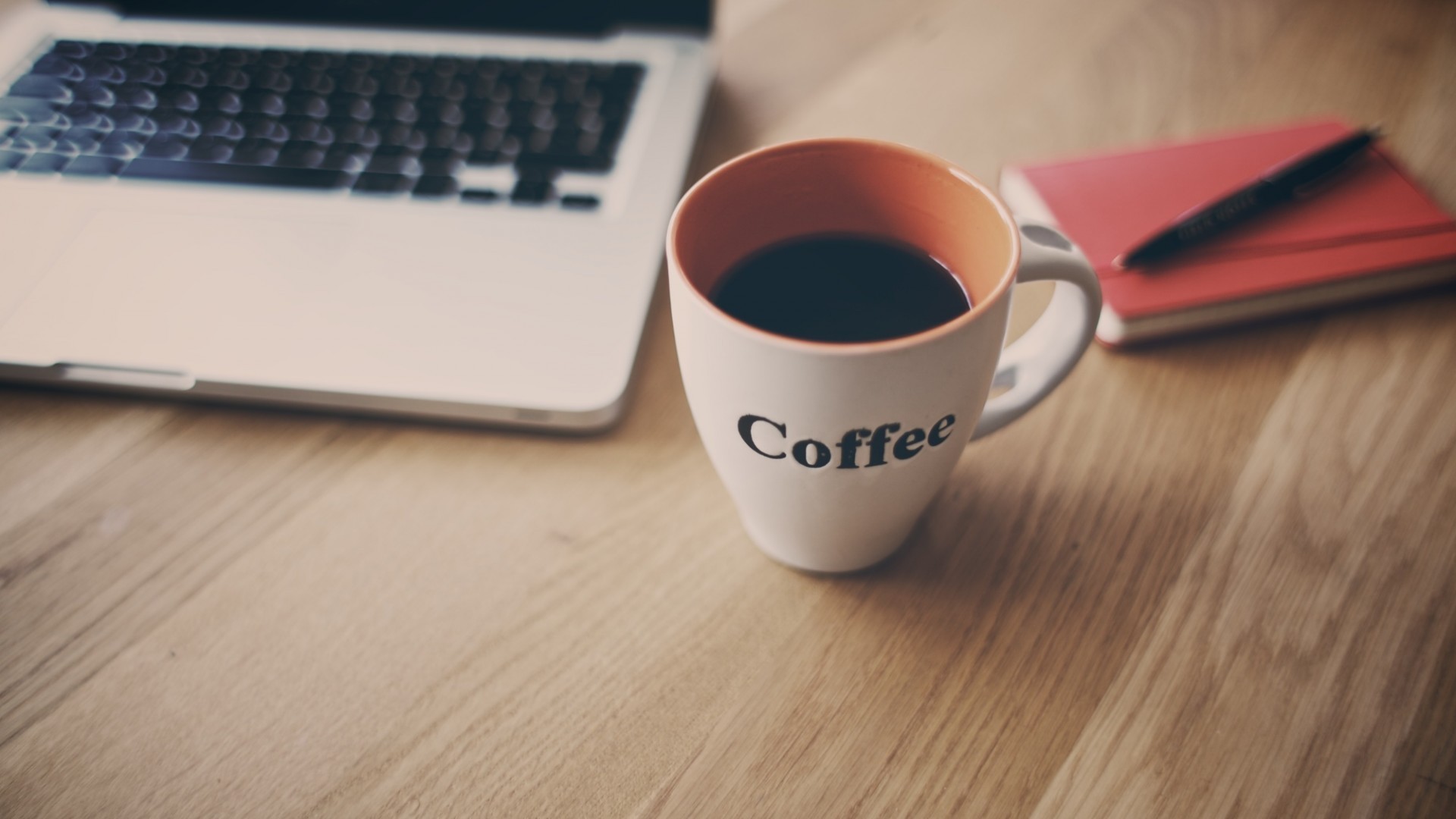Laptop, coffee cup, and notebook on a wooden desk HD Wallpaper