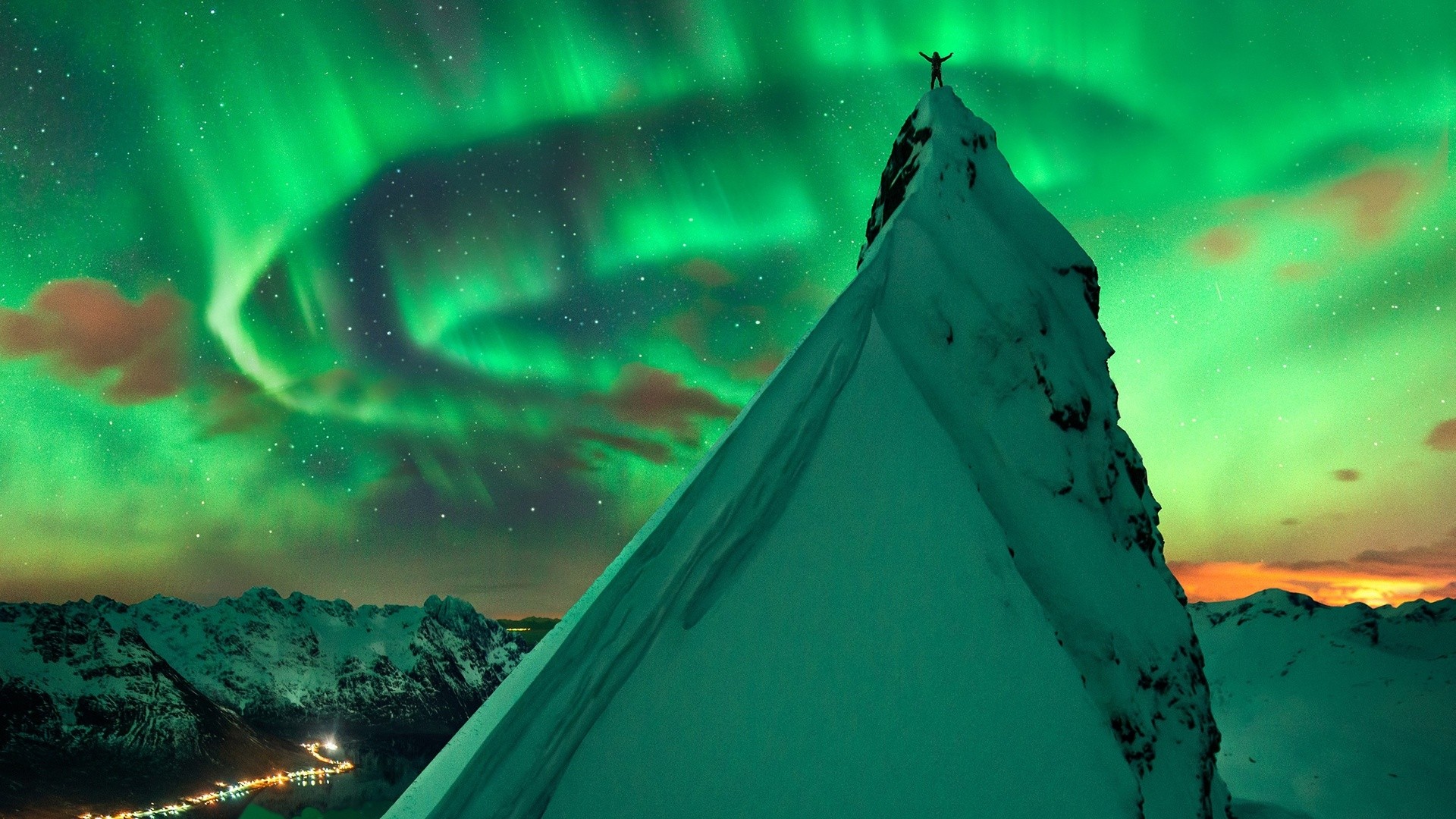 Man on mountain peak under Aurora Borealis in Norway HD Wallpaper