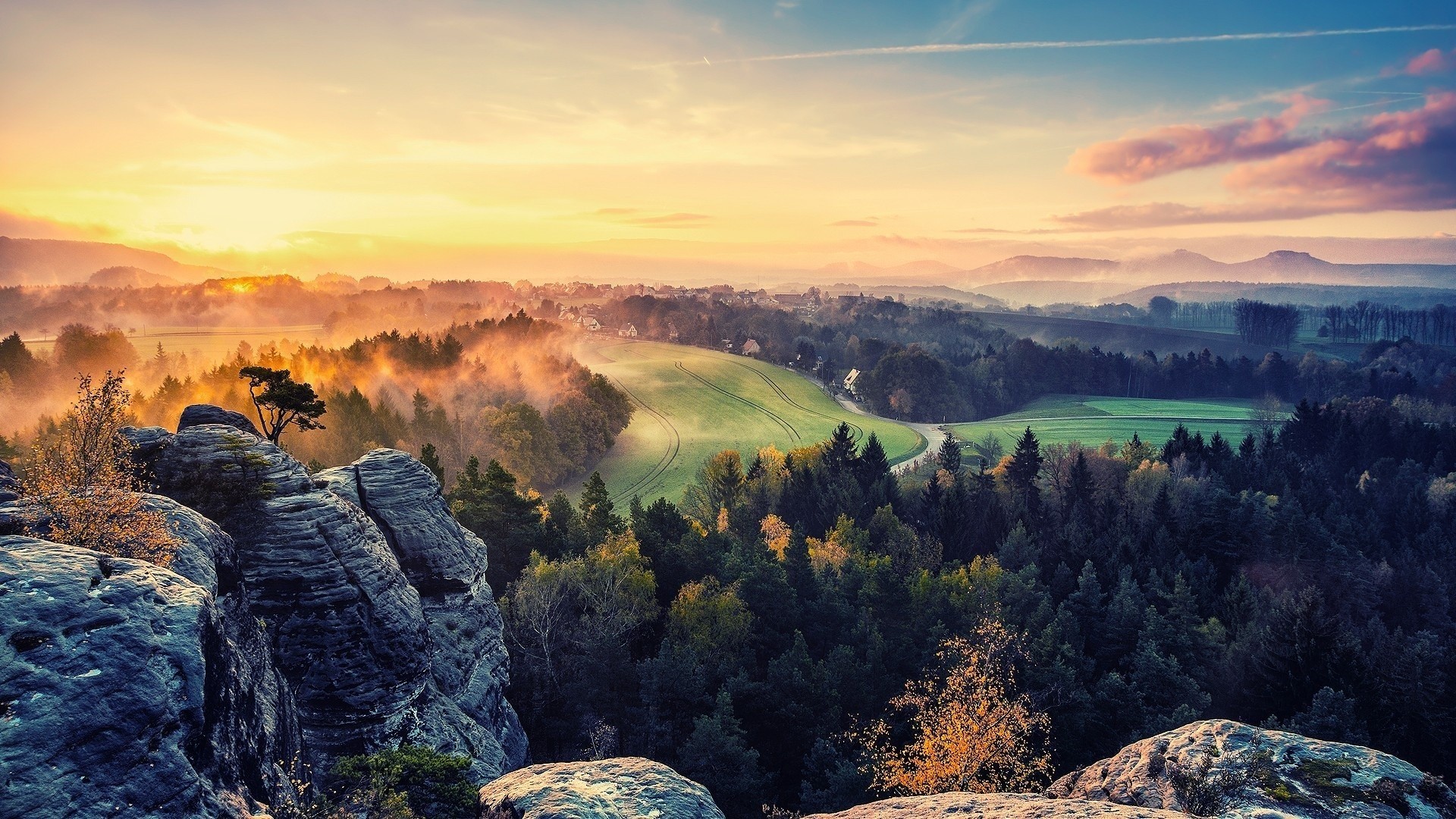 Misty mountain landscape at sunrise with rocky foreground HD Wallpaper
