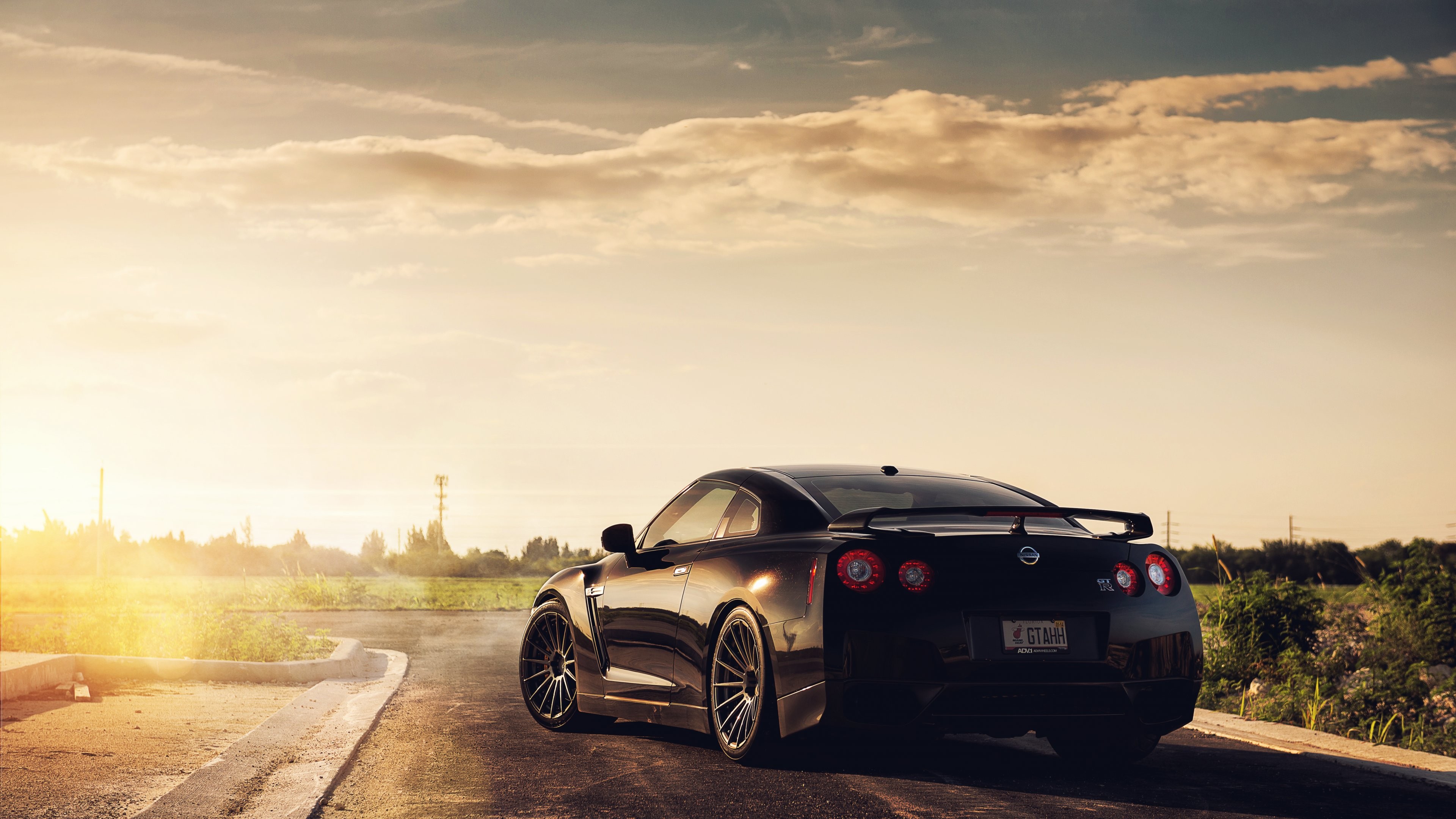 Black Nissan GT-R on a road at sunset HD Wallpaper