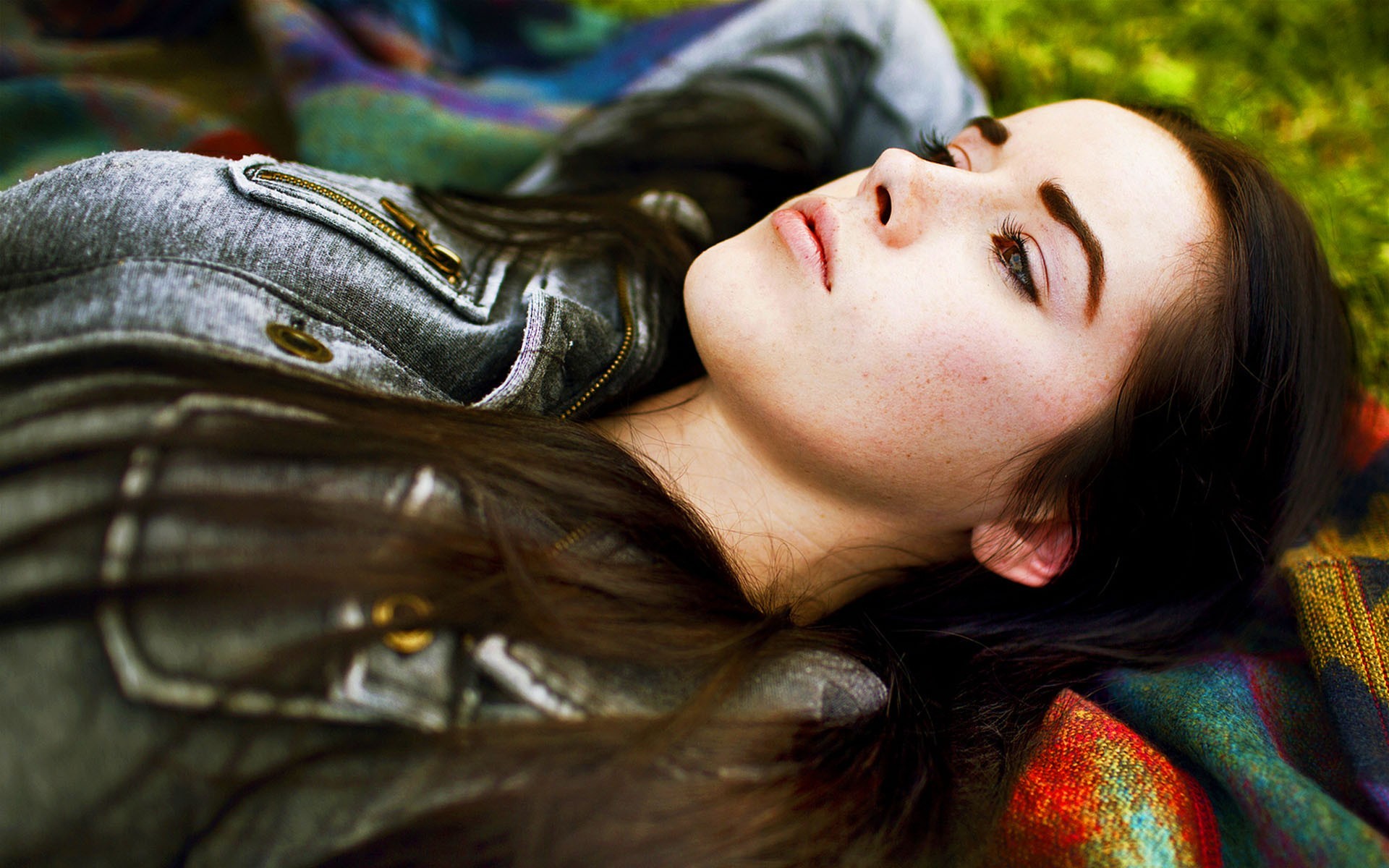 Woman lying on a colorful blanket outdoors HD Wallpaper