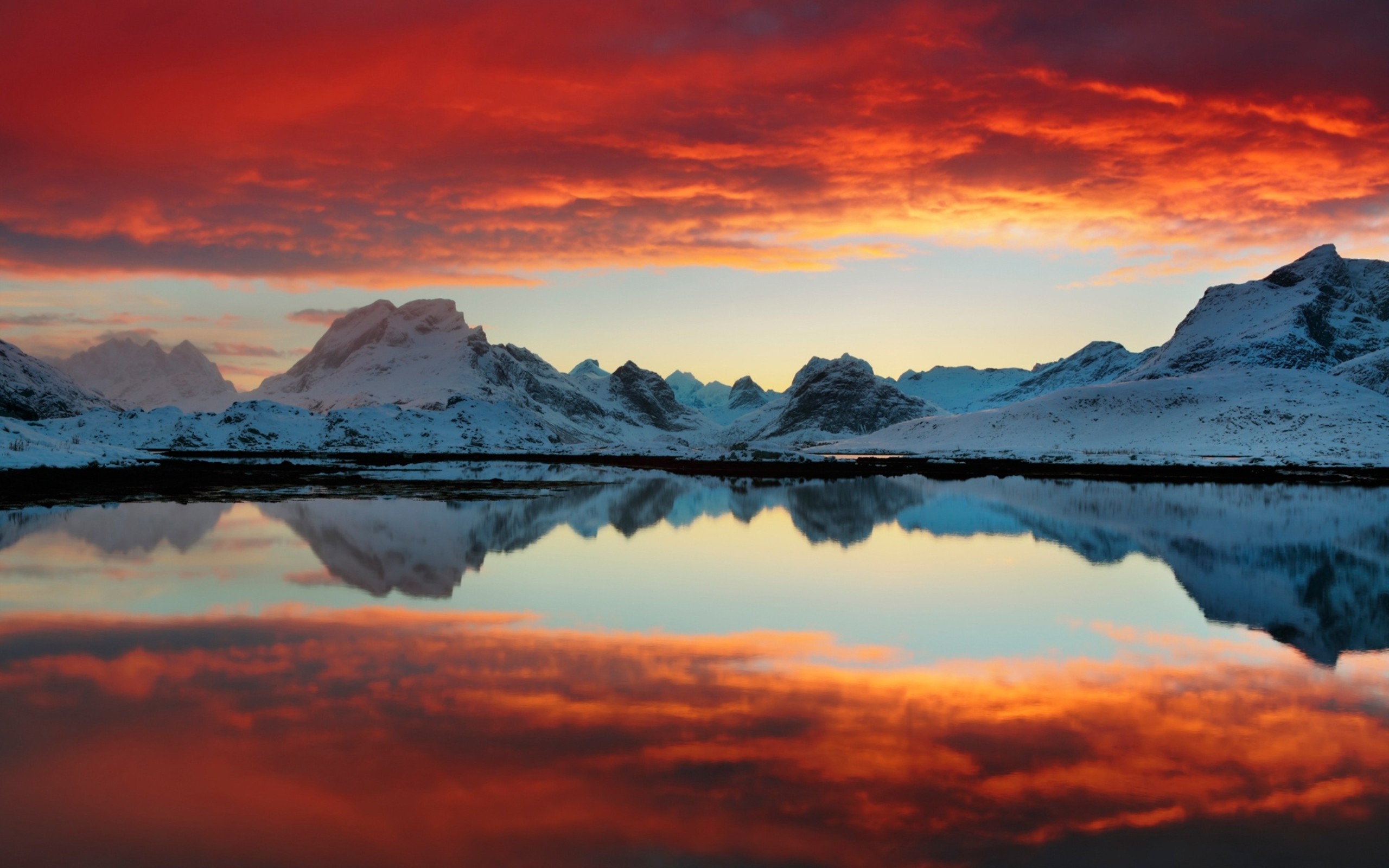 Snowy mountains reflected in a calm lake at sunset HD Wallpaper