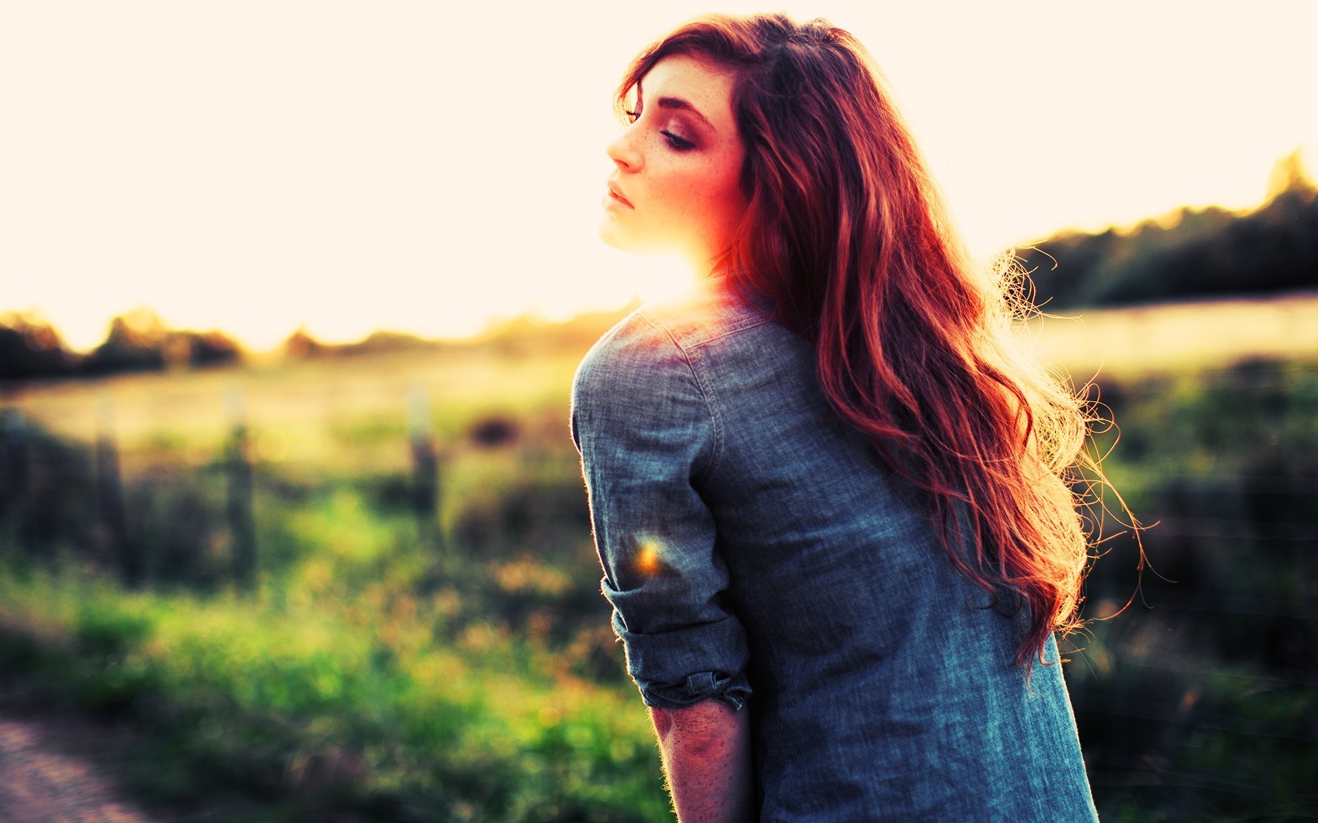 Woman with long red hair in a field at sunset HD Wallpaper