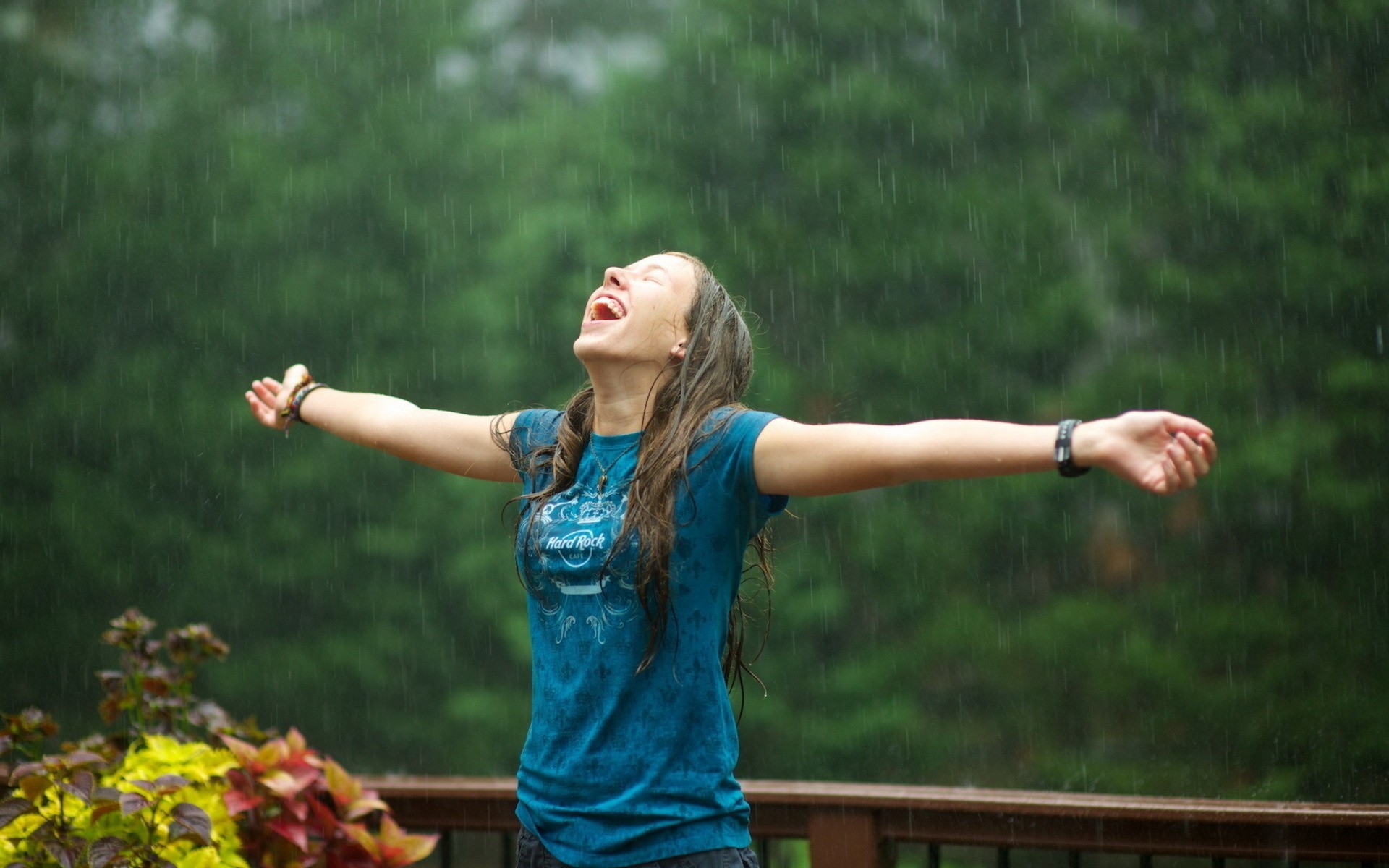 Woman enjoying the rain with arms outstretched HD Wallpaper