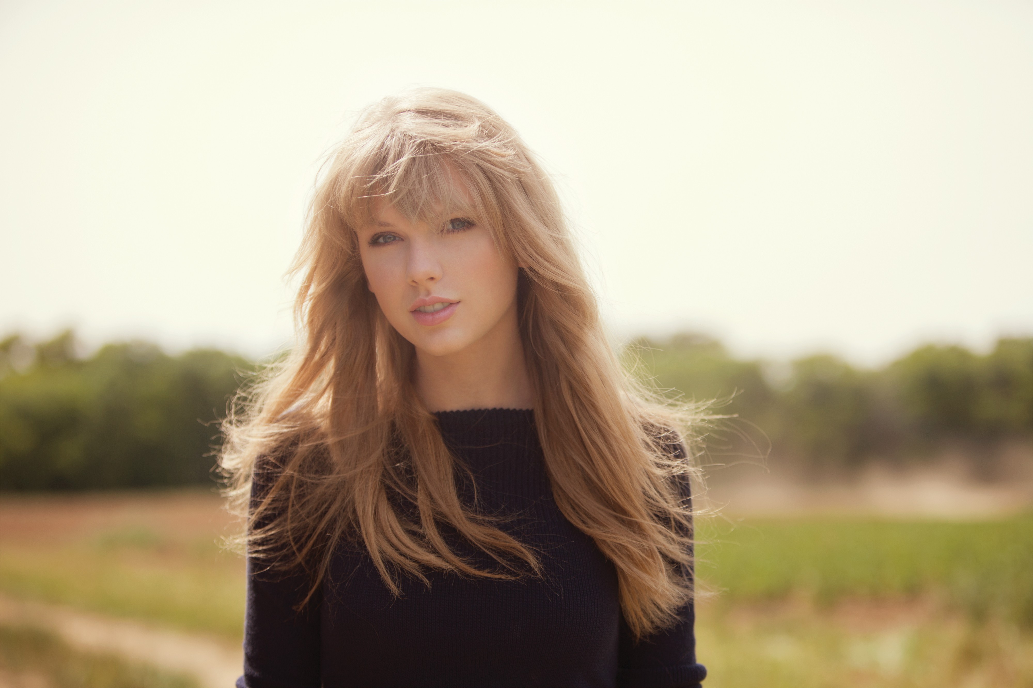 Taylor Swift in a dark sweater outdoors HD Wallpaper