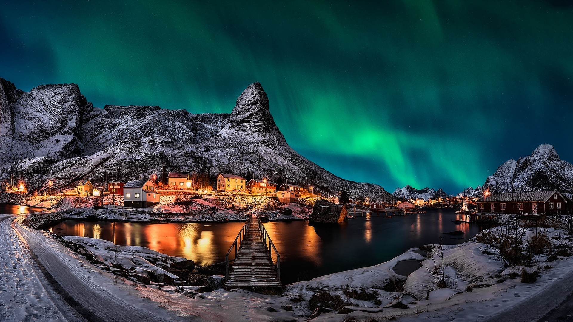 Aurora Borealis over a Norwegian village with snowy mountains HD Wallpaper