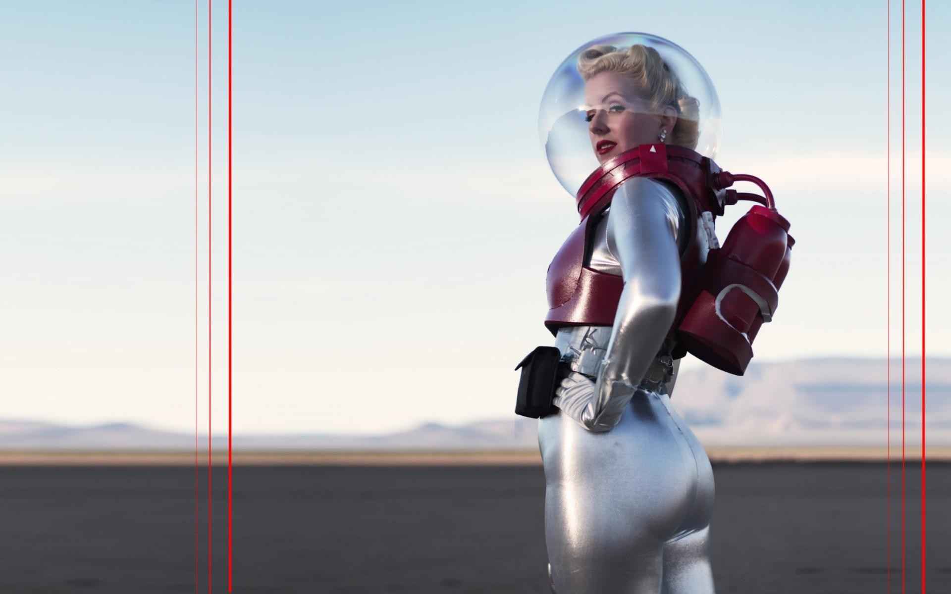 Woman in a retro-style silver spacesuit with a red helmet HD Wallpaper
