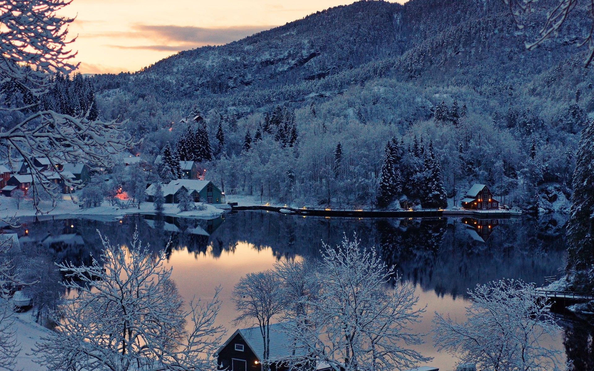 Snowy forest and lake with houses at dusk HD Wallpaper