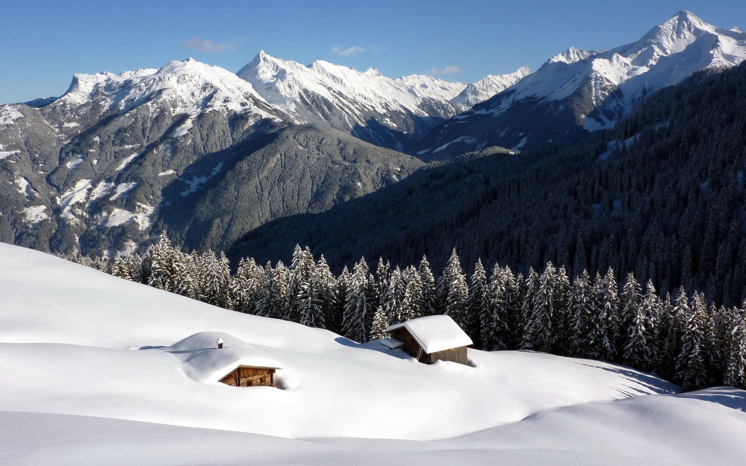 Snow-covered mountains and forest with cabins HD Wallpaper