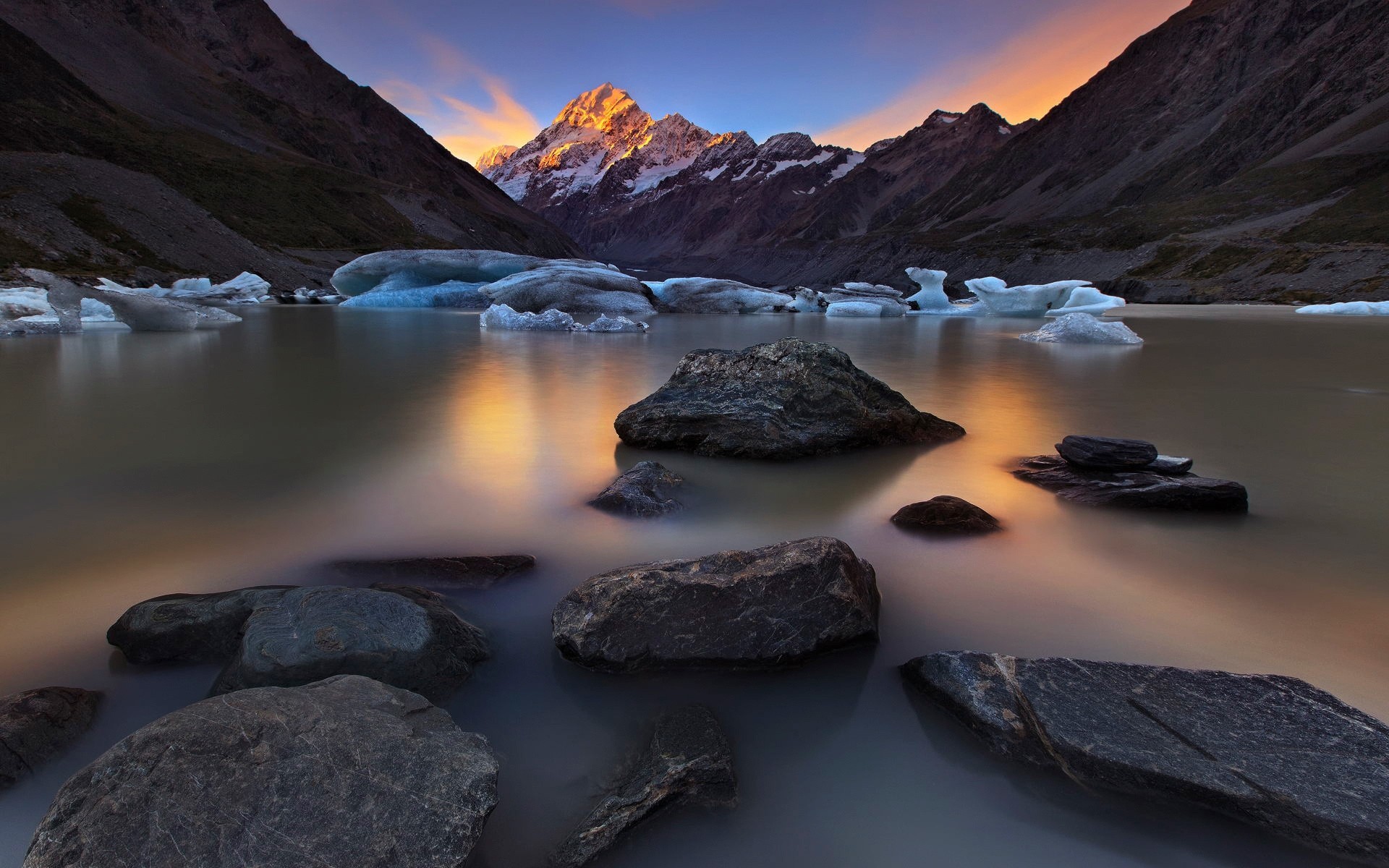 Mountaintop lake with icebergs and rocks at sunset HD Wallpaper