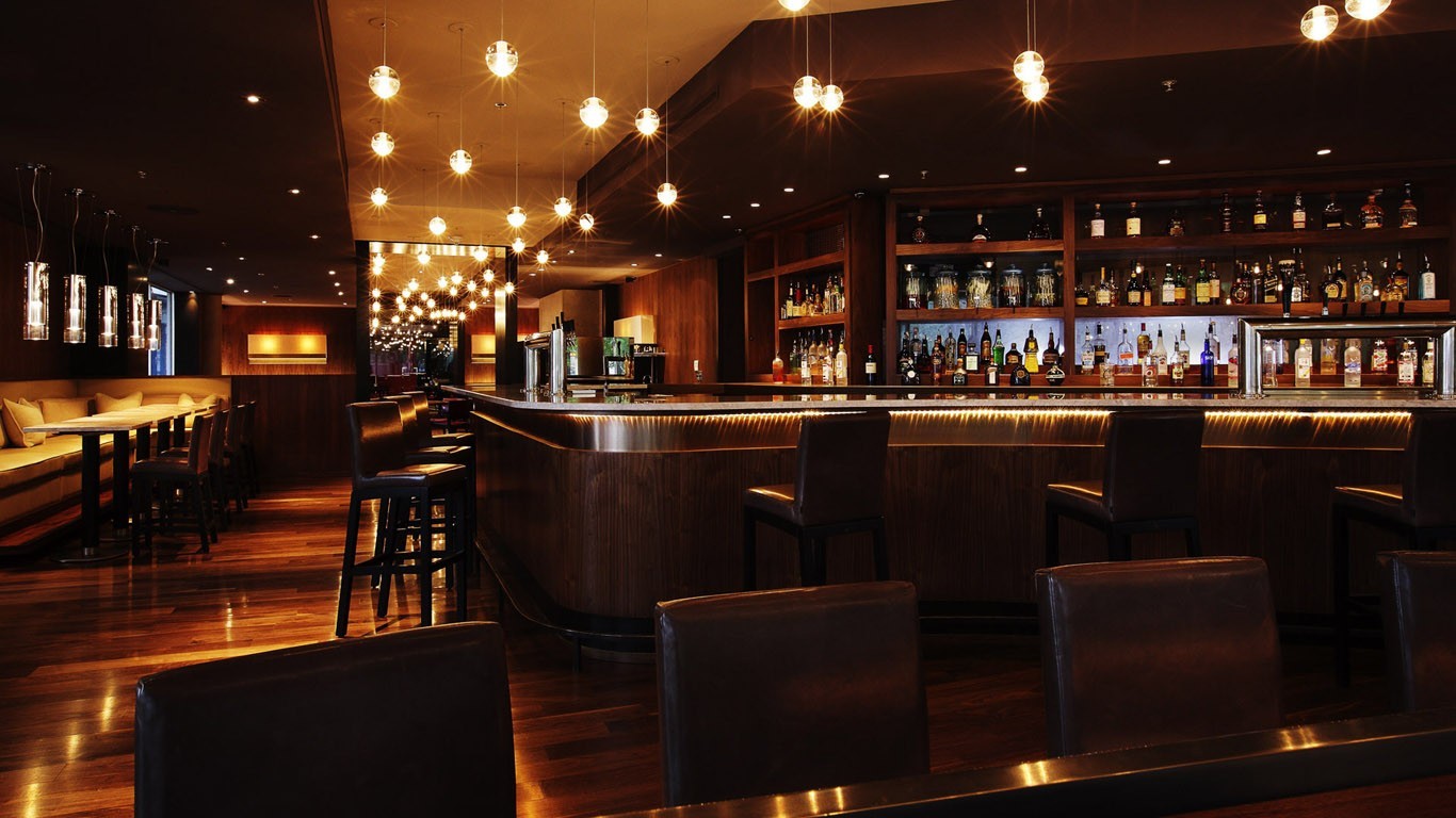 Interior of a dimly lit bar with a long counter HD Wallpaper