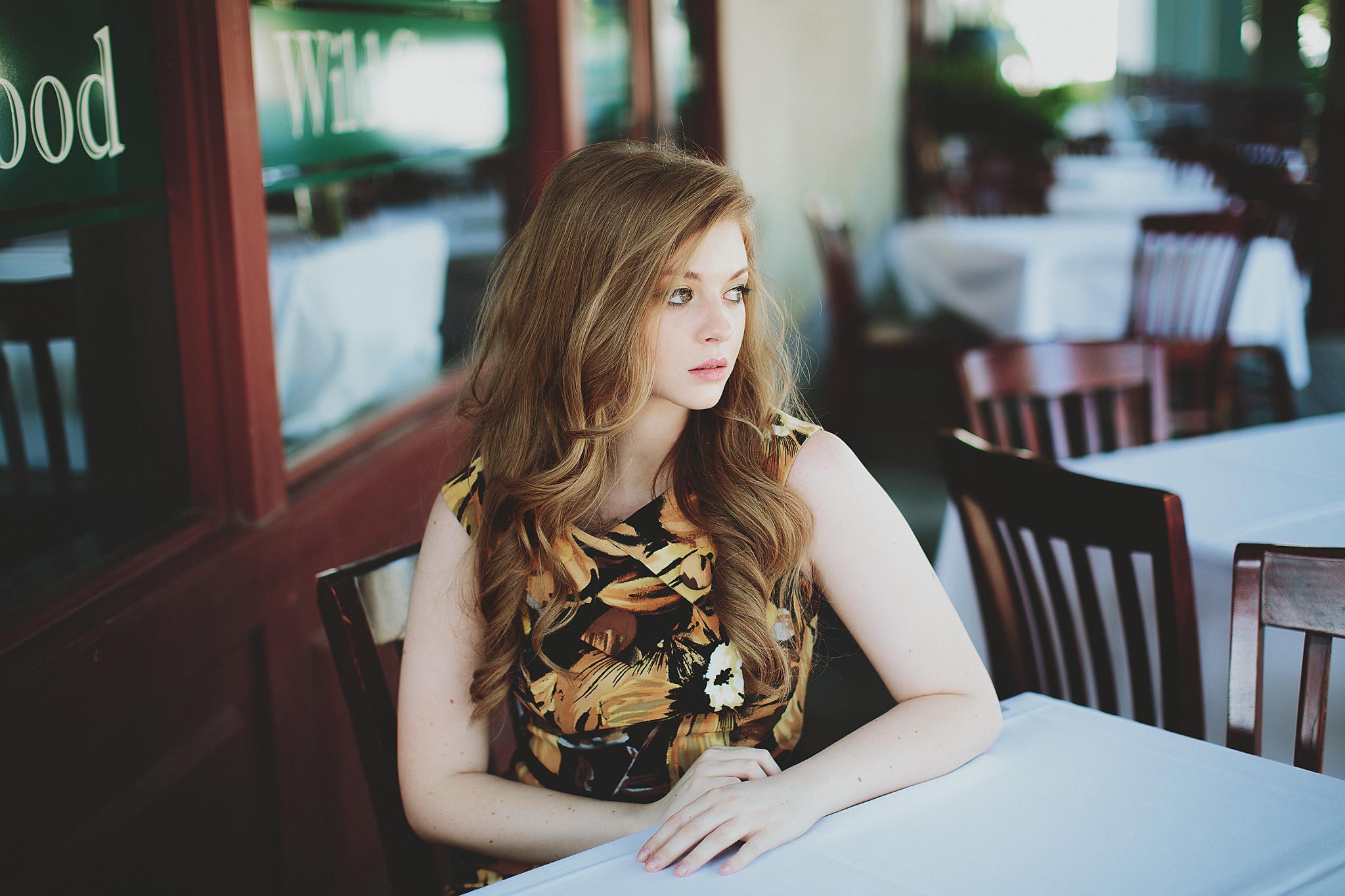 Woman sitting at a table outside a restaurant HD Wallpaper