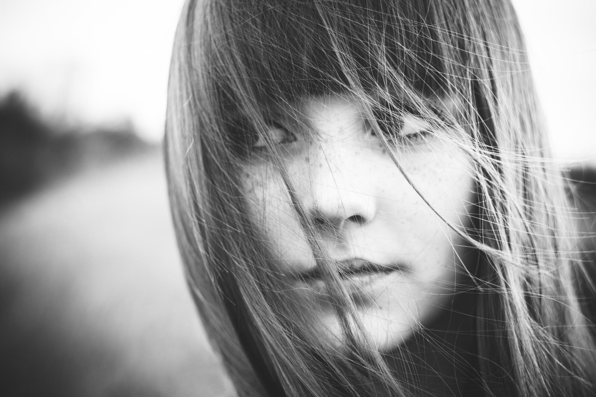 Monochrome portrait of a young woman with hair covering her face HD Wallpaper