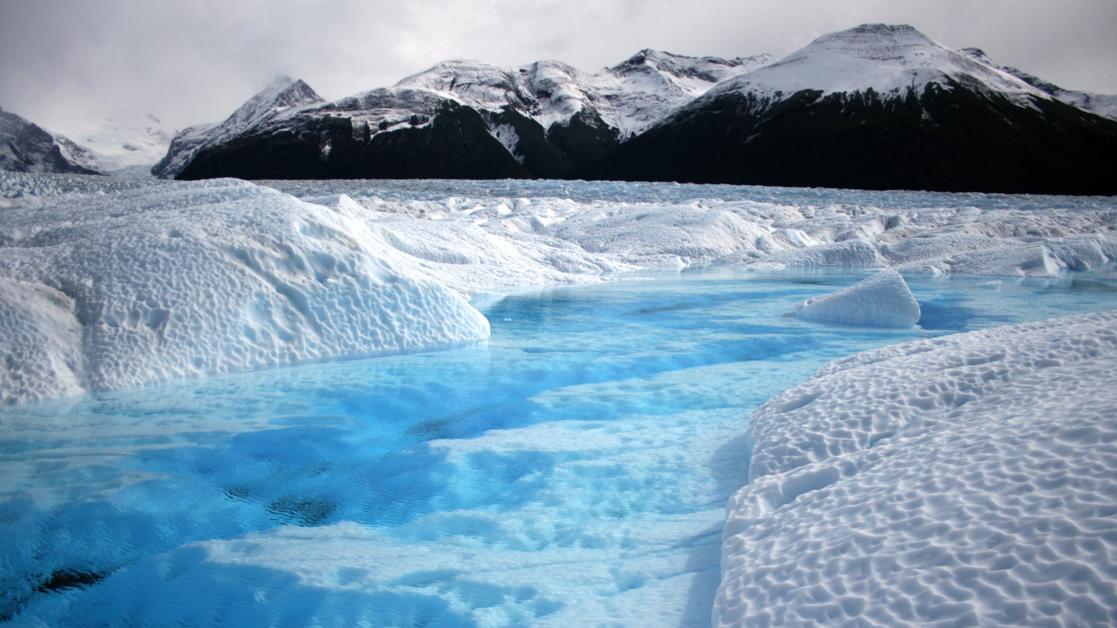Glaciers and snow-capped mountains under a cloudy sky HD Wallpaper