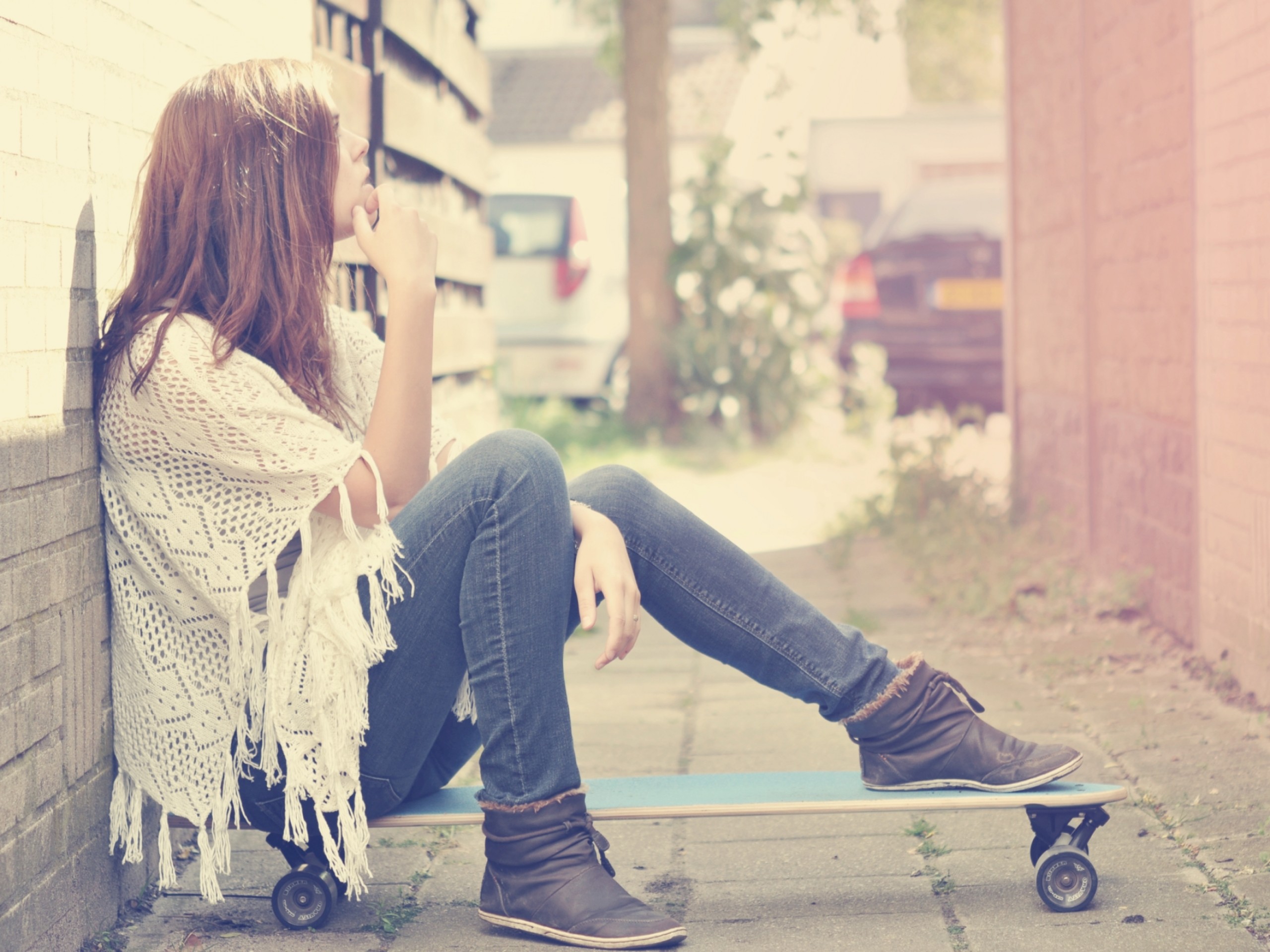 Woman sitting on a skateboard outdoors HD Wallpaper