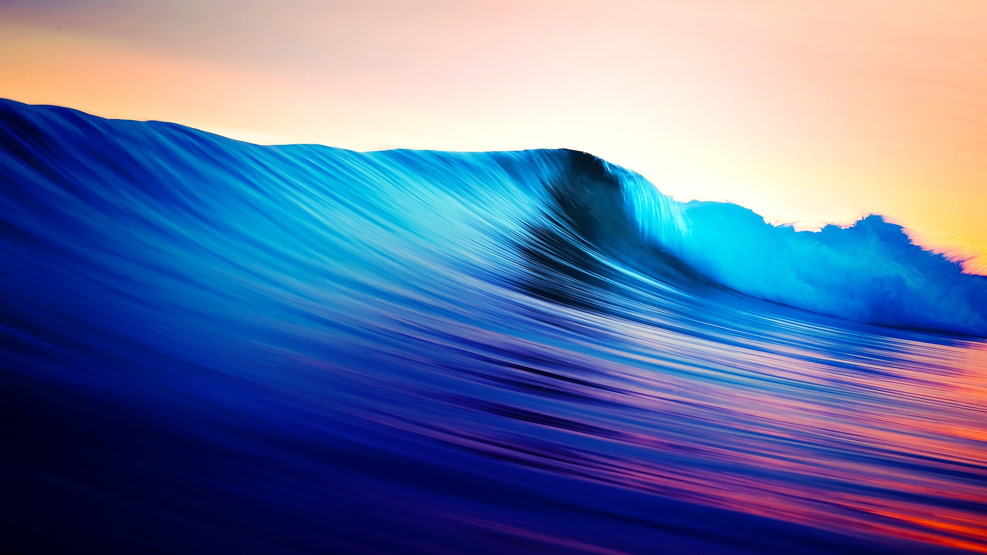 A large blue wave crests against a soft orange sky. HD Wallpaper