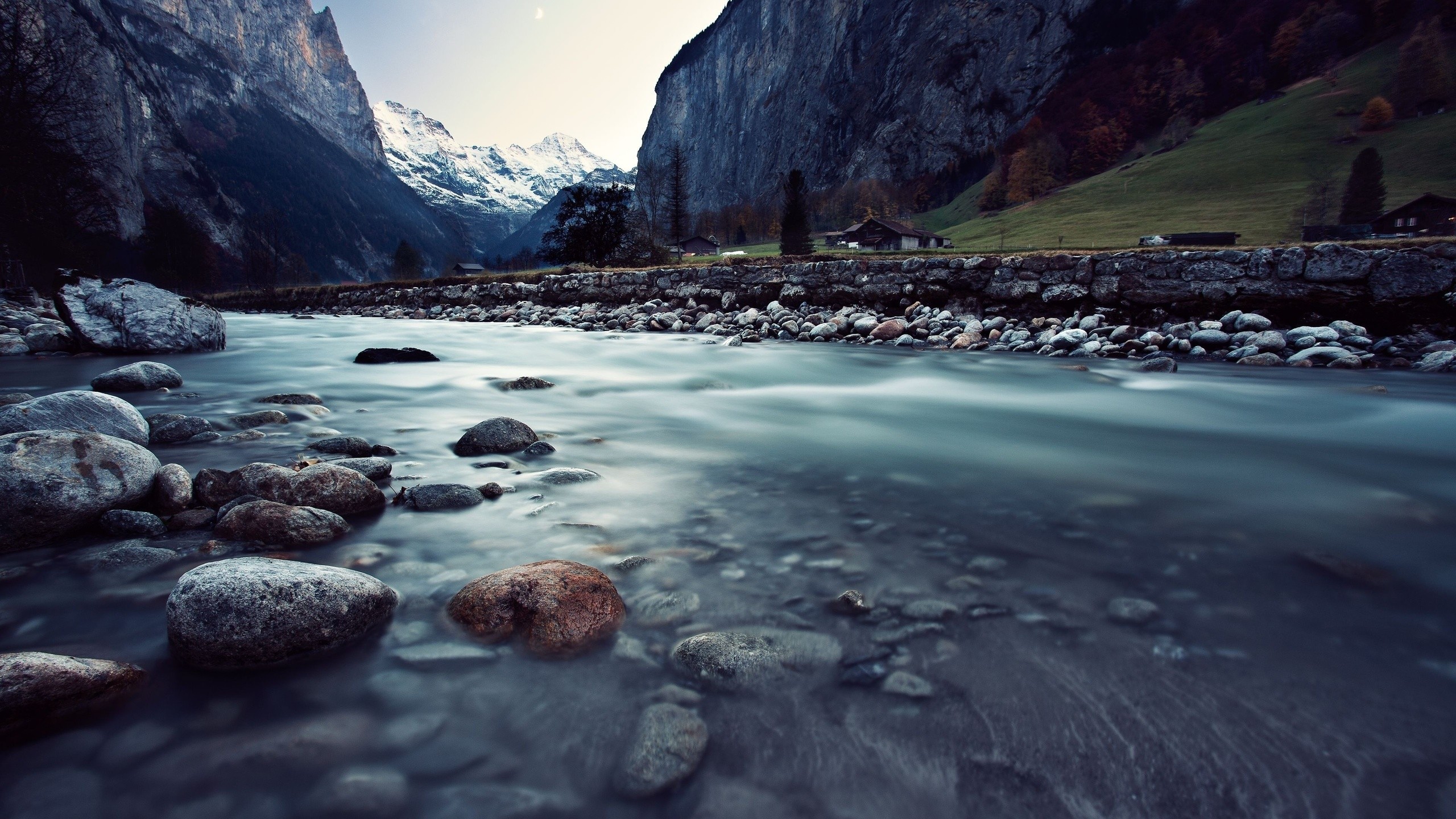 River flowing through a mountain valley with snow-capped peaks HD Wallpaper