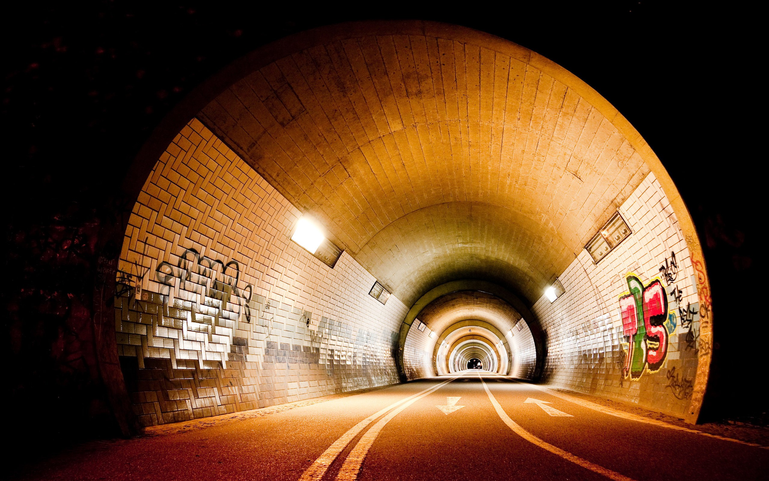 Graffiti tunnel with lights and road markings HD Wallpaper