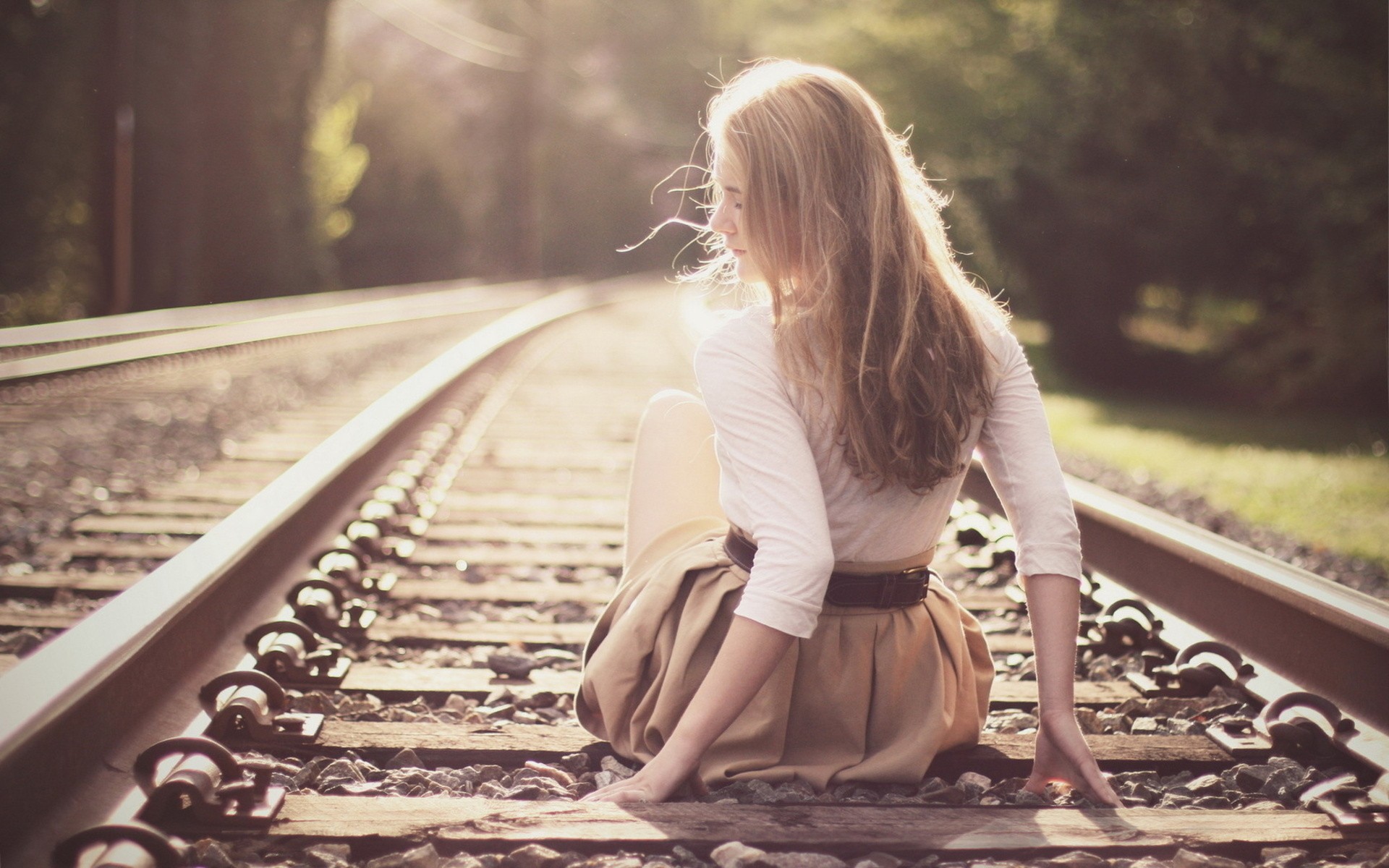 Woman with long blonde hair sitting on train tracks HD Wallpaper