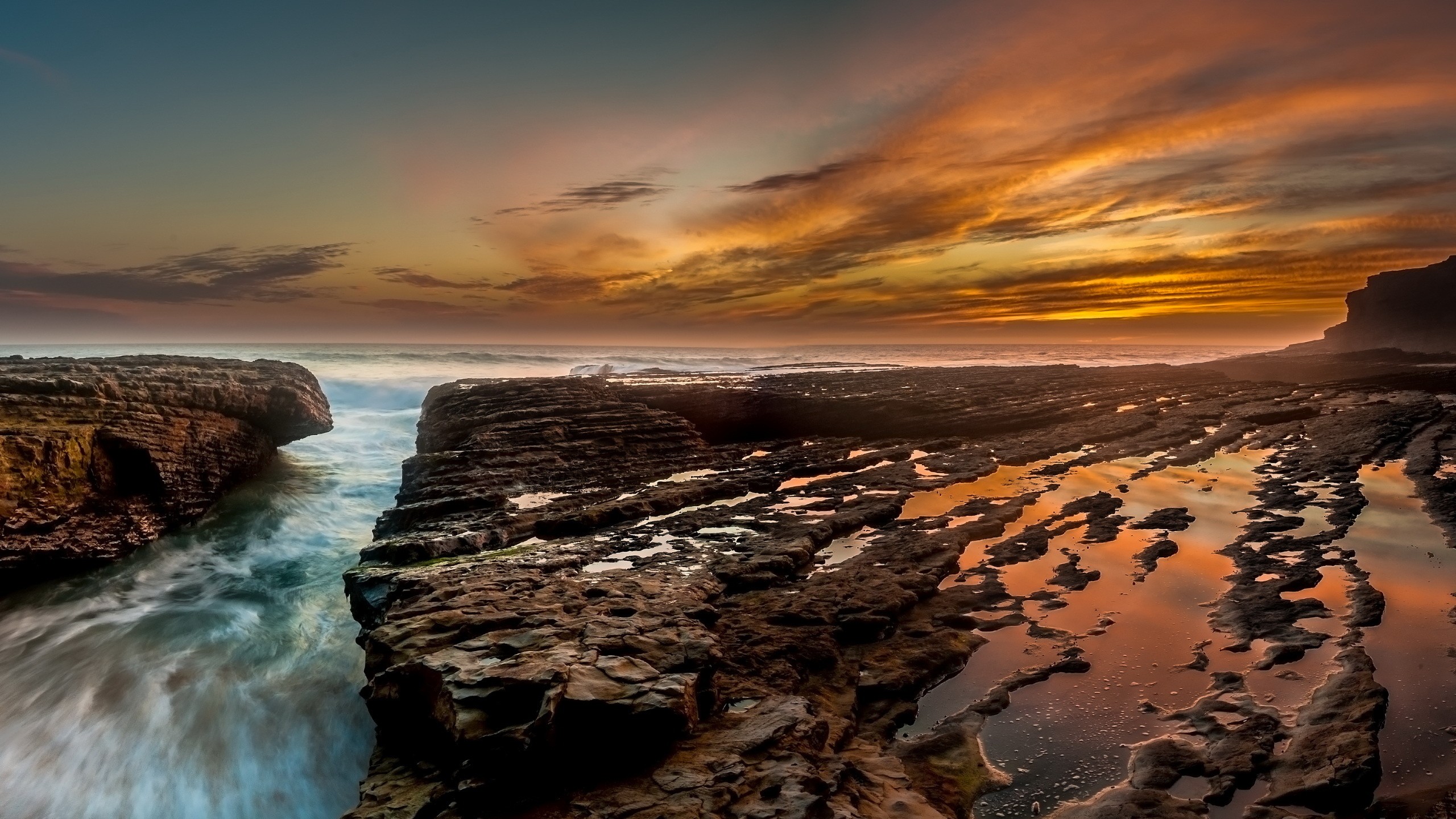 Sunset over rocky coast with ocean waves HD Wallpaper