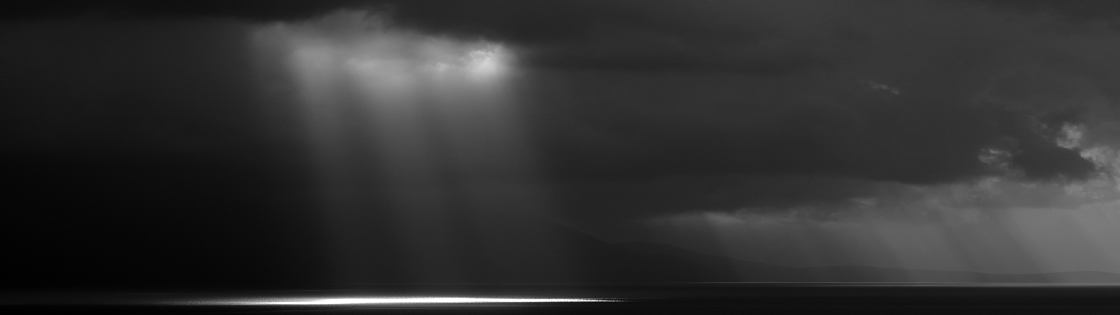 Monochrome landscape with dramatic sunbeams over water HD Wallpaper