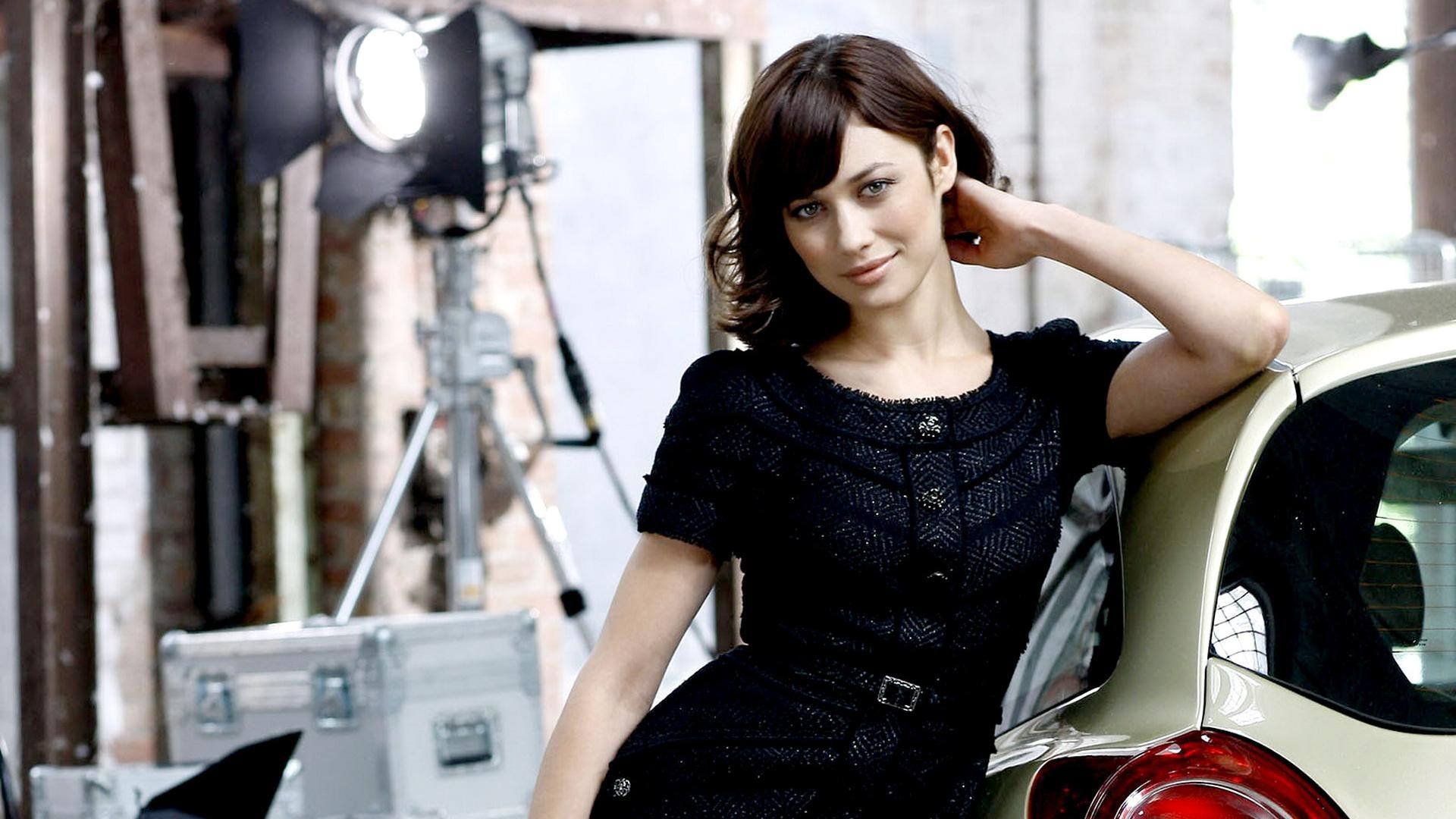 Olga Kurylenko posing with a car HD Wallpaper