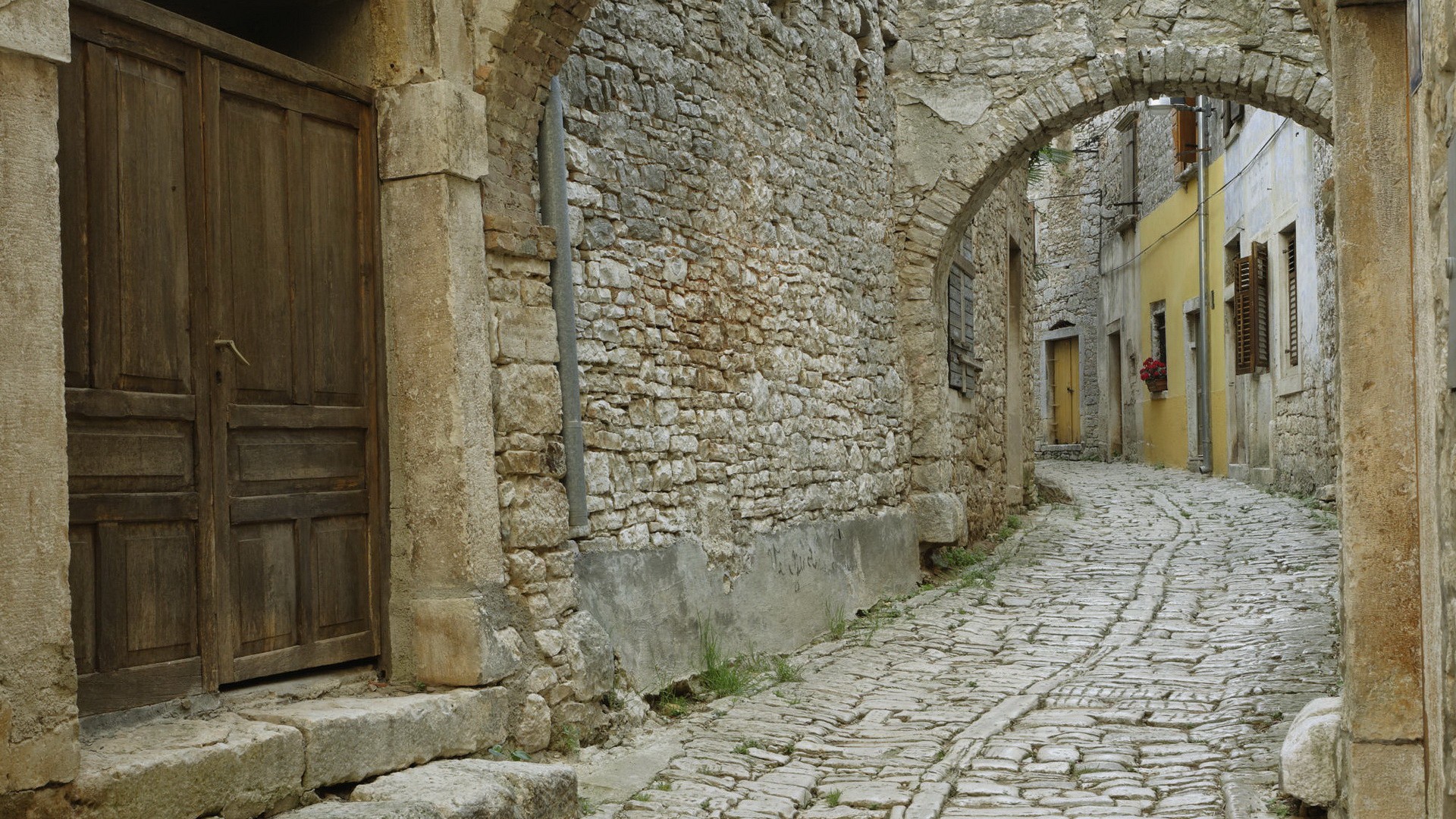 Old stone street with arched passage HD Wallpaper