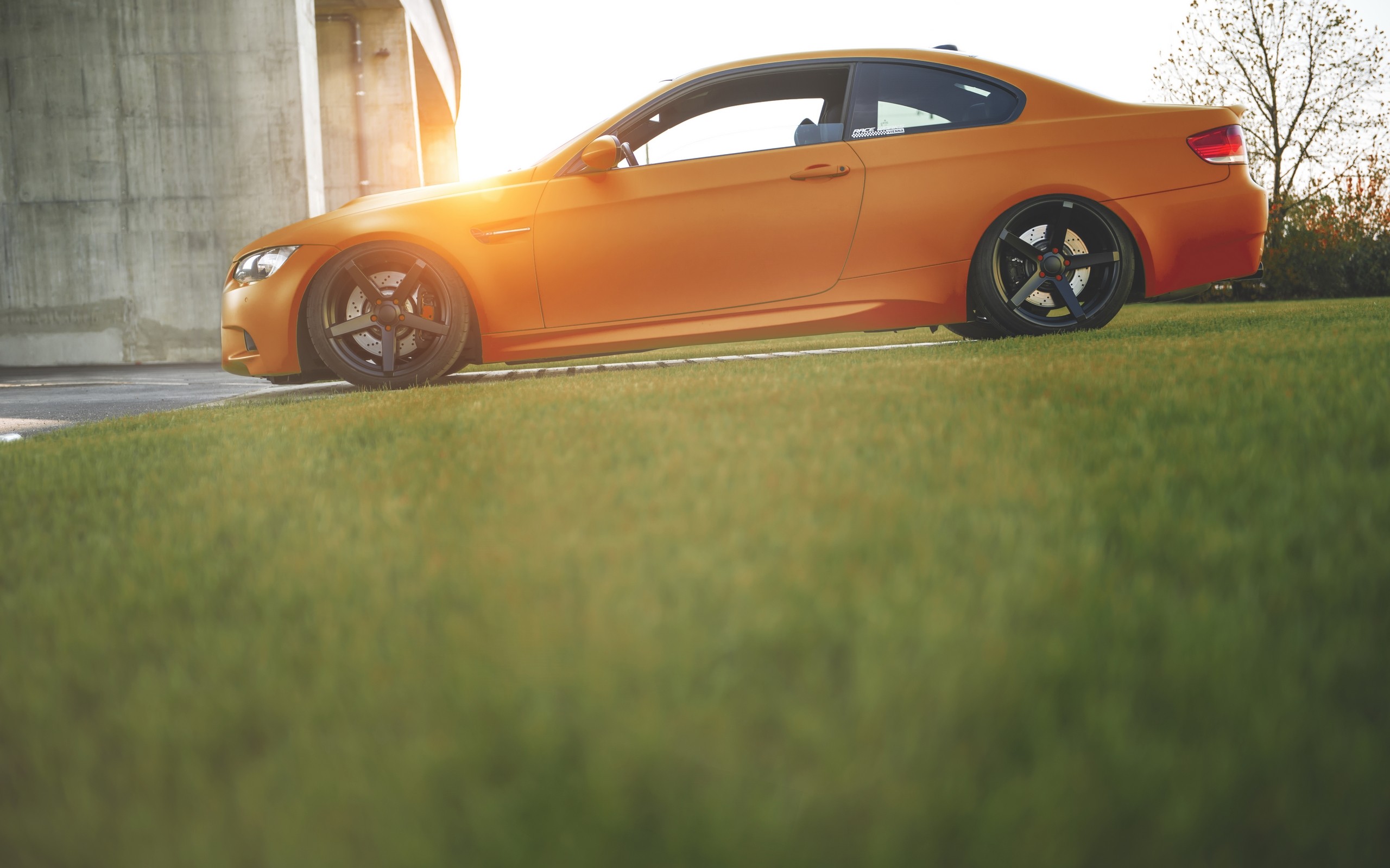 Orange BMW E92 parked on grass during sunset HD Wallpaper