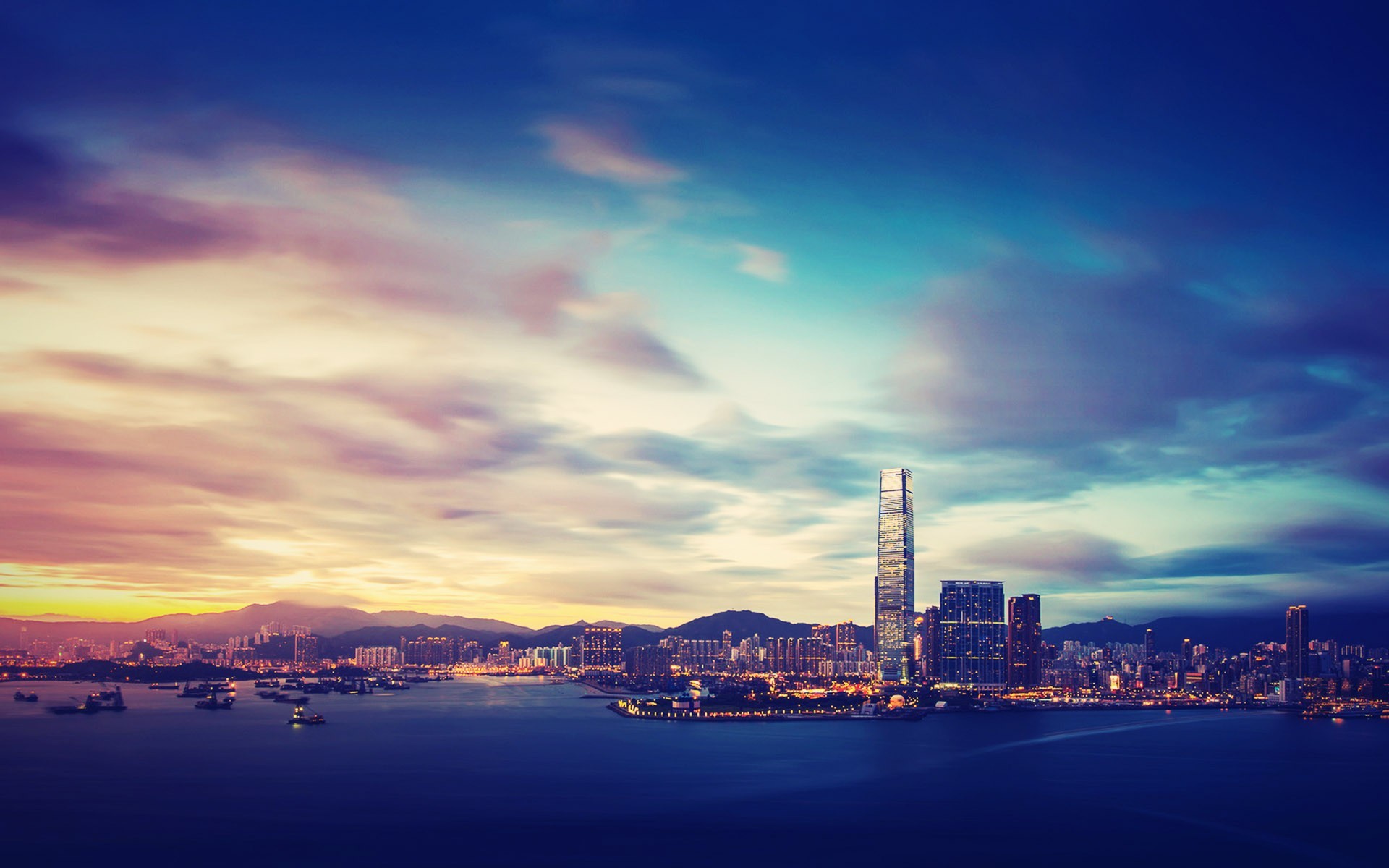 Hong Kong cityscape at dusk with harbor and mountains HD Wallpaper