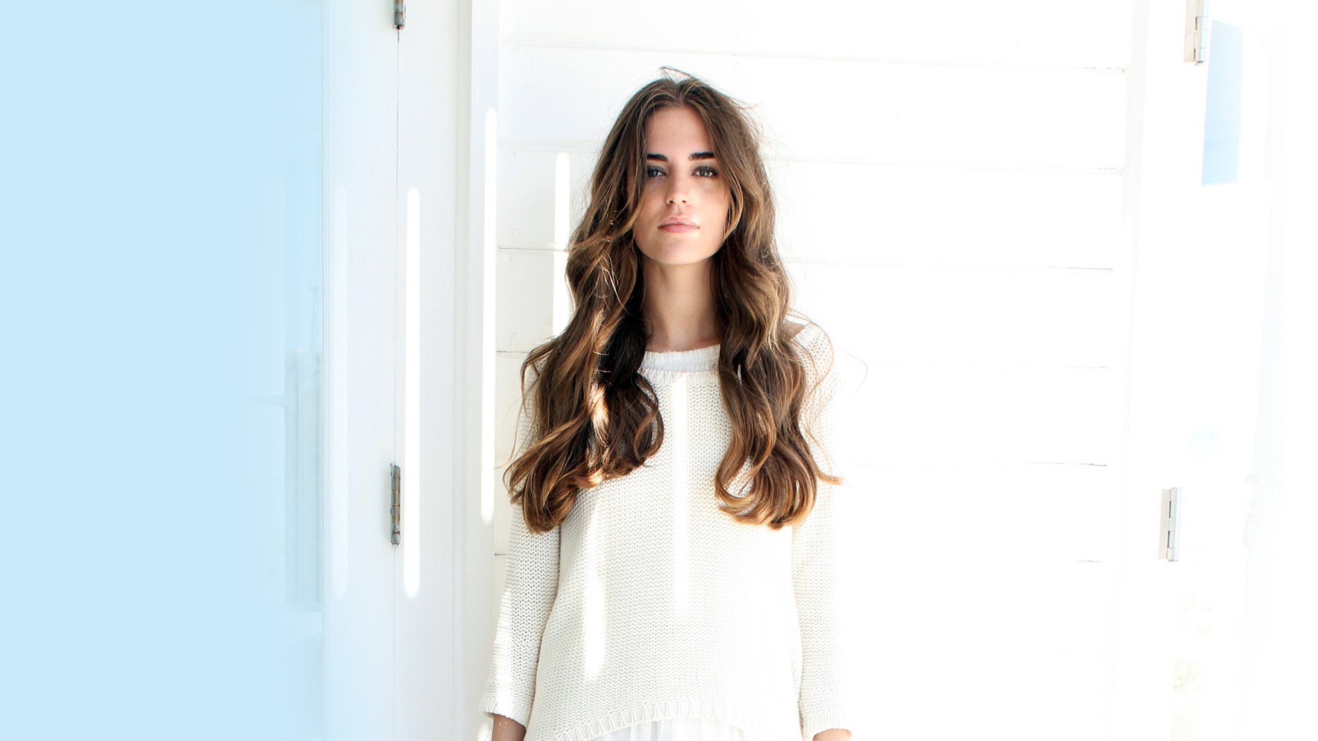 Brunette woman with long wavy hair wearing a white sweater HD Wallpaper