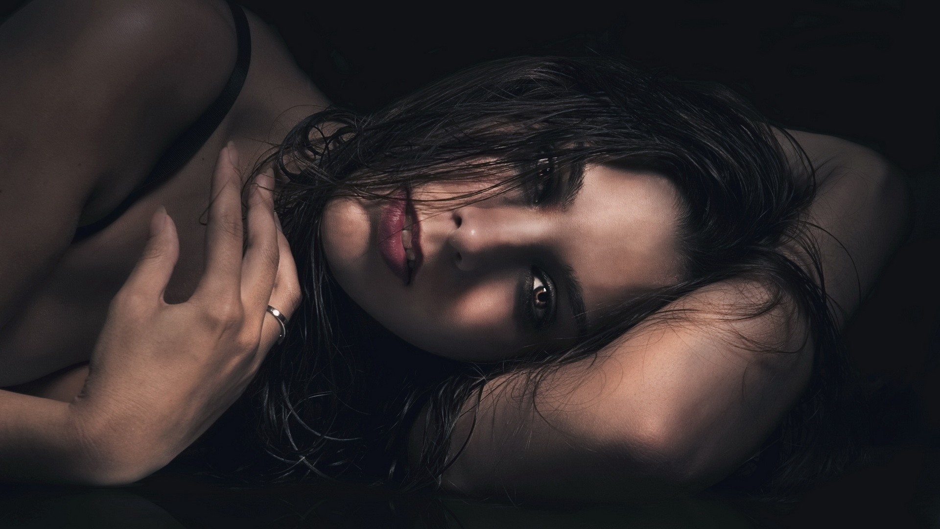 Woman with dark hair lying down HD Wallpaper